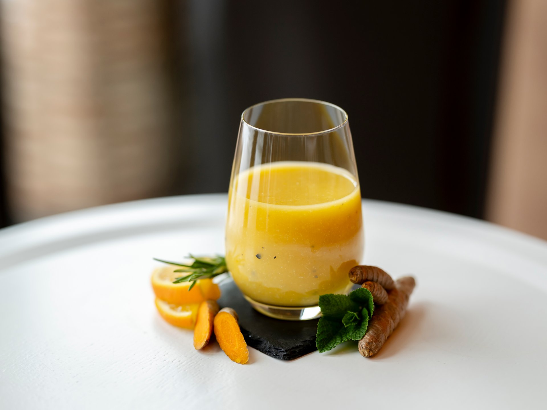 Seezeit re.connect – Bewusste Verbindung mit Natur & Kraftort Gelber Kurkuma-Saft in Glas mit frischen Kurkumastücken und Zitronenscheiben