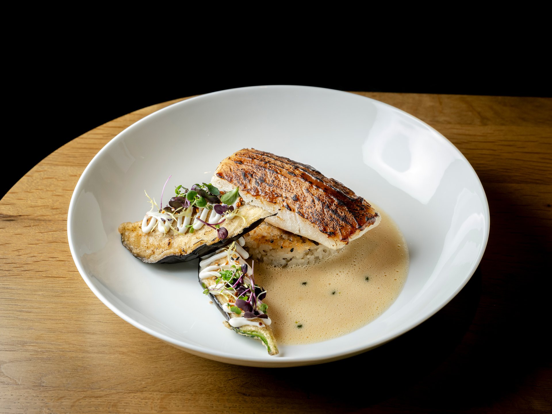 Seezeit re.connect – Bewusste Verbindung mit Natur & Kraftort Gebratenes Fischfilet mit Gemüse und Sauce auf weißem Teller