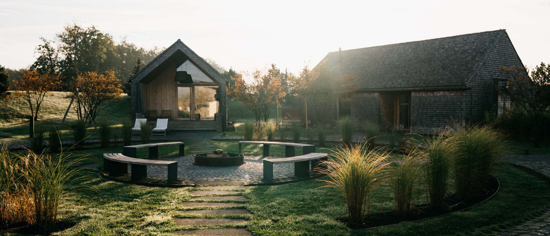Seezeitlodge: Bildergalerie Weg zu zwei Häusern mit Sitzbereich und Garten in der Morgensonne