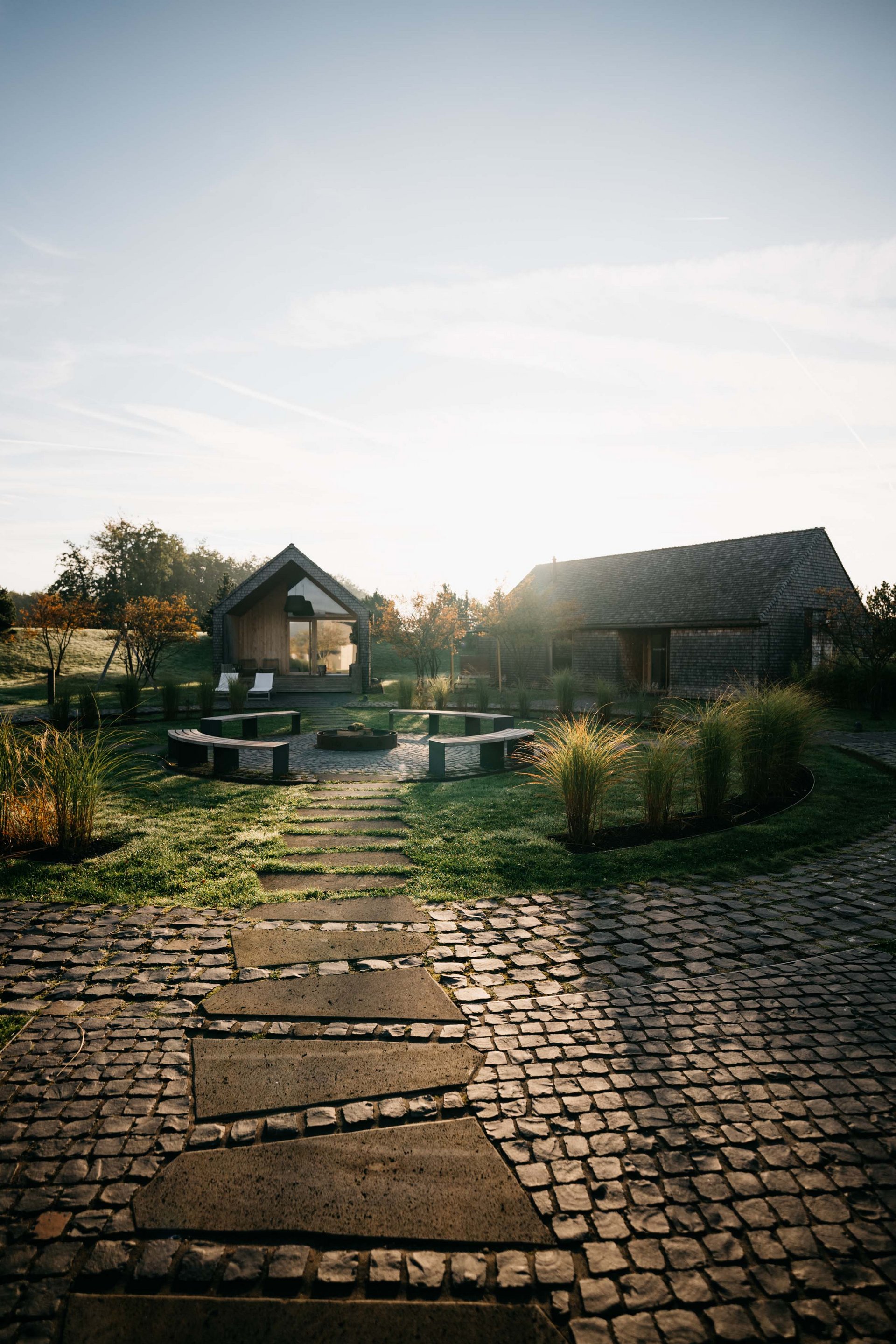 Seezeitlodge : Galerie photos Sentier menant à deux maisons avec espace de détente et jardin au lever du soleil