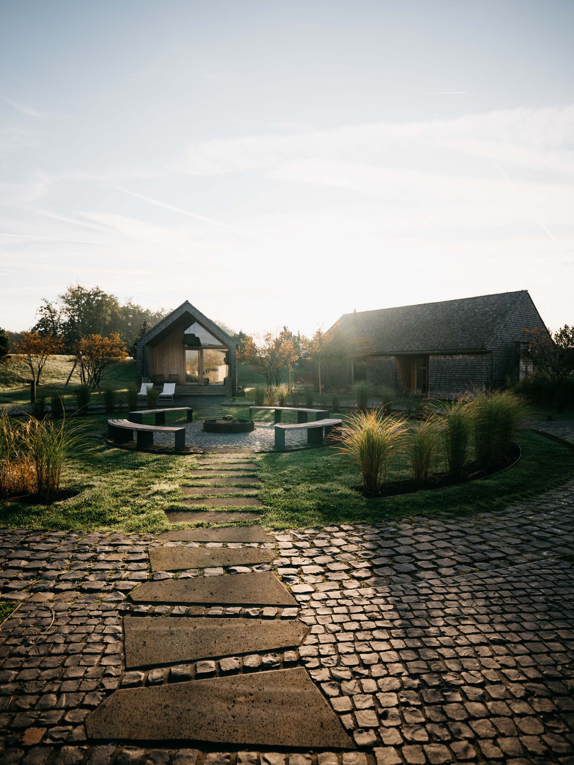 Seezeitlodge : Galerie photos Sentier menant à deux maisons avec espace de détente et jardin au lever du soleil