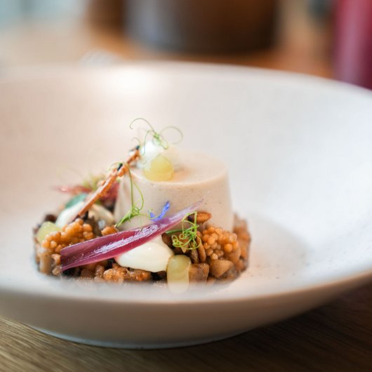 LUMI: our restaurant at Lake Bostalsee Gourmet appetizer with cream, pearls, onion, and herbs on a white plate