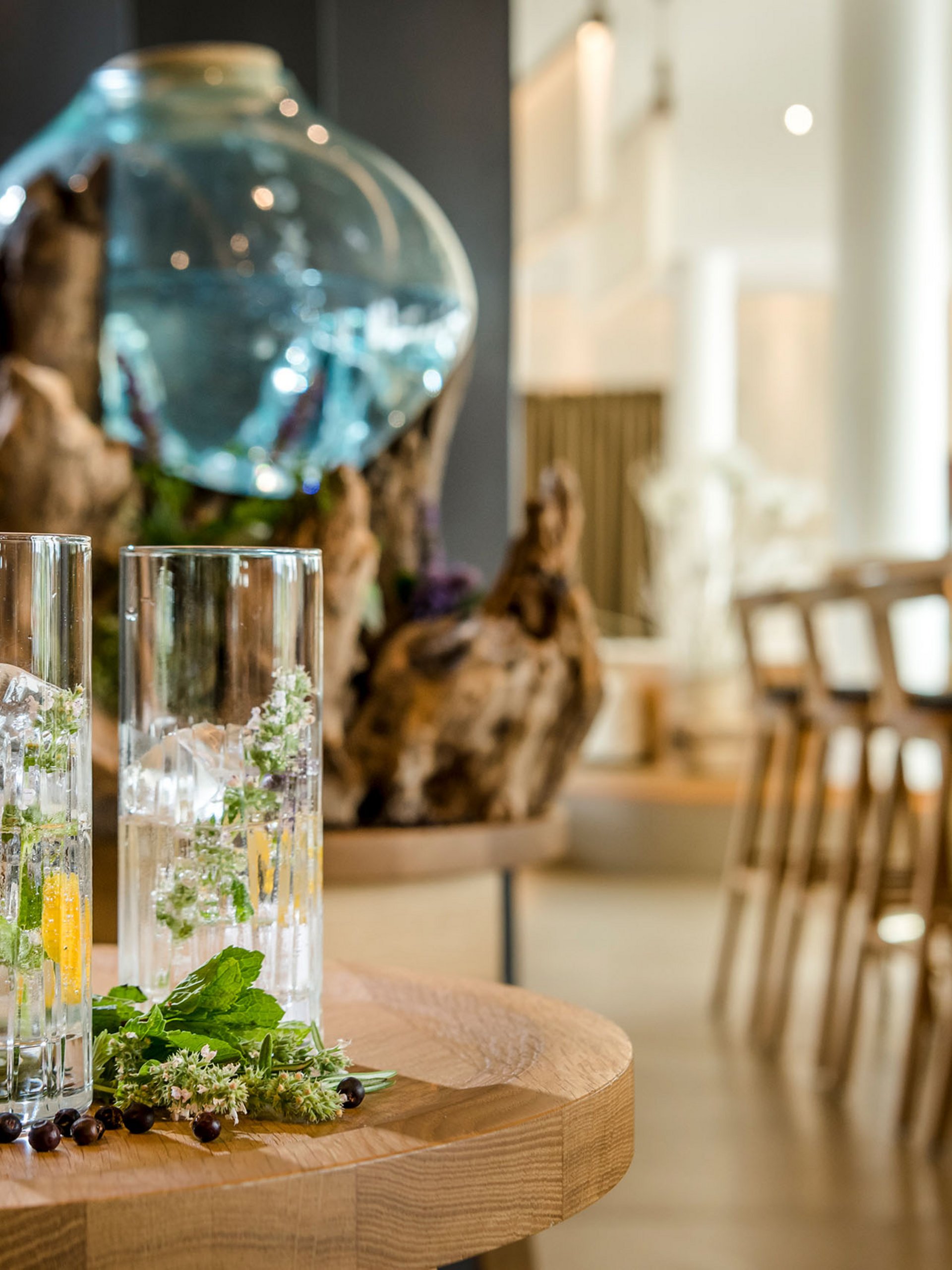 Seezeitlodge: Bildergalerie Zwei Gläser mit Eis und Kräutern auf einem Holztisch in einer Bar