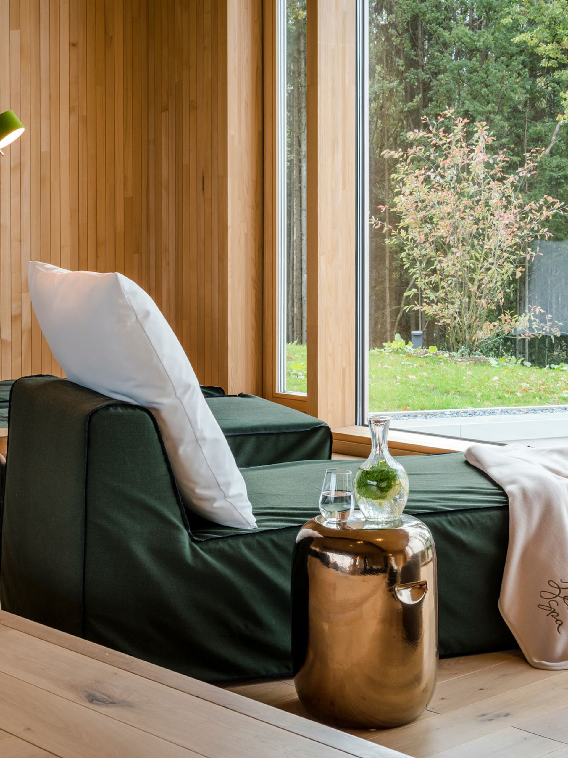 Seezeitlodge: Bildergalerie Entspannungsbereich mit Liegestuhl, Kissen, Decke und grünem Ausblick