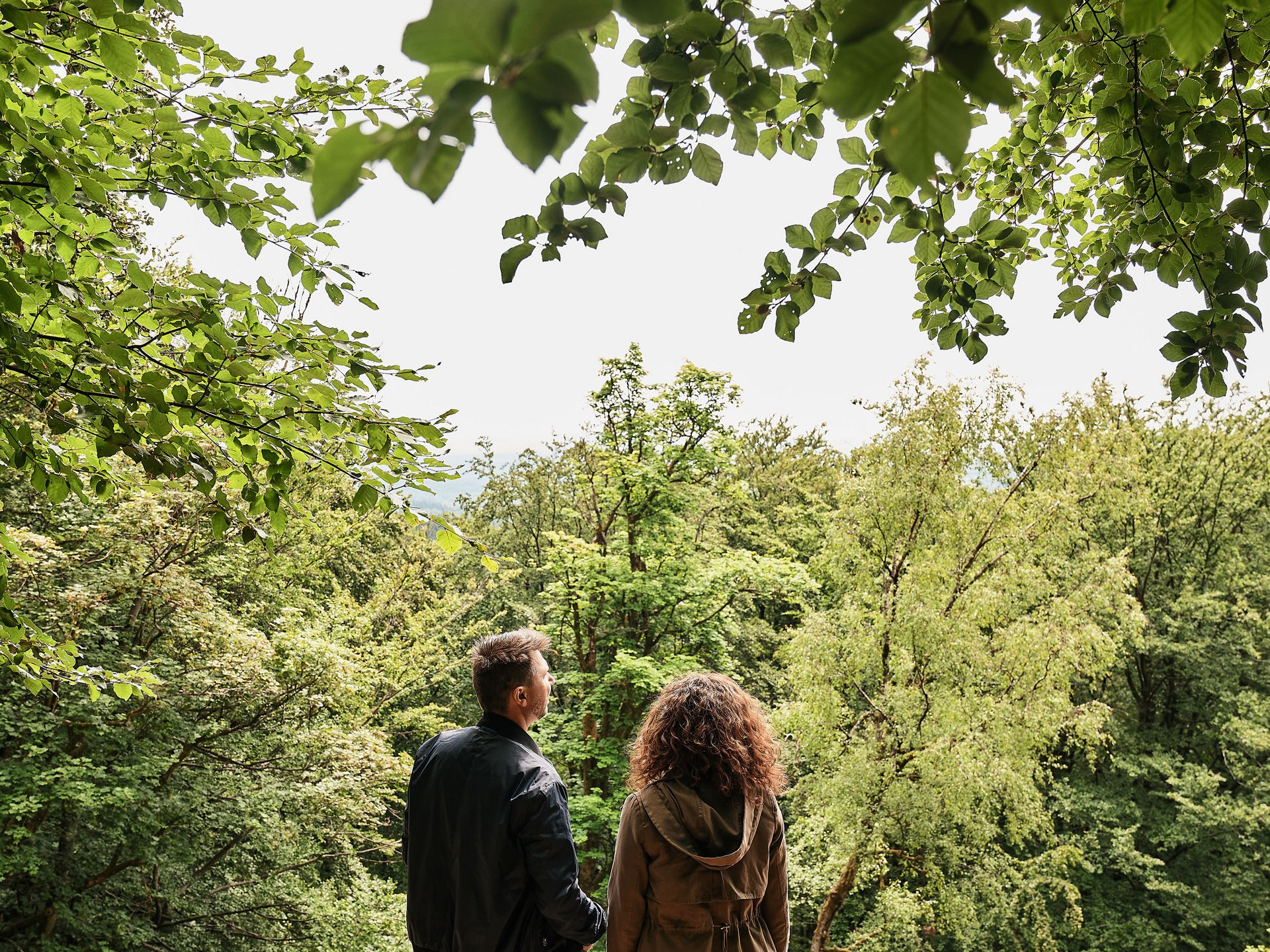 Seezeitlodge: Bildergalerie Paar steht im Wald und blickt auf Bäume und Natur