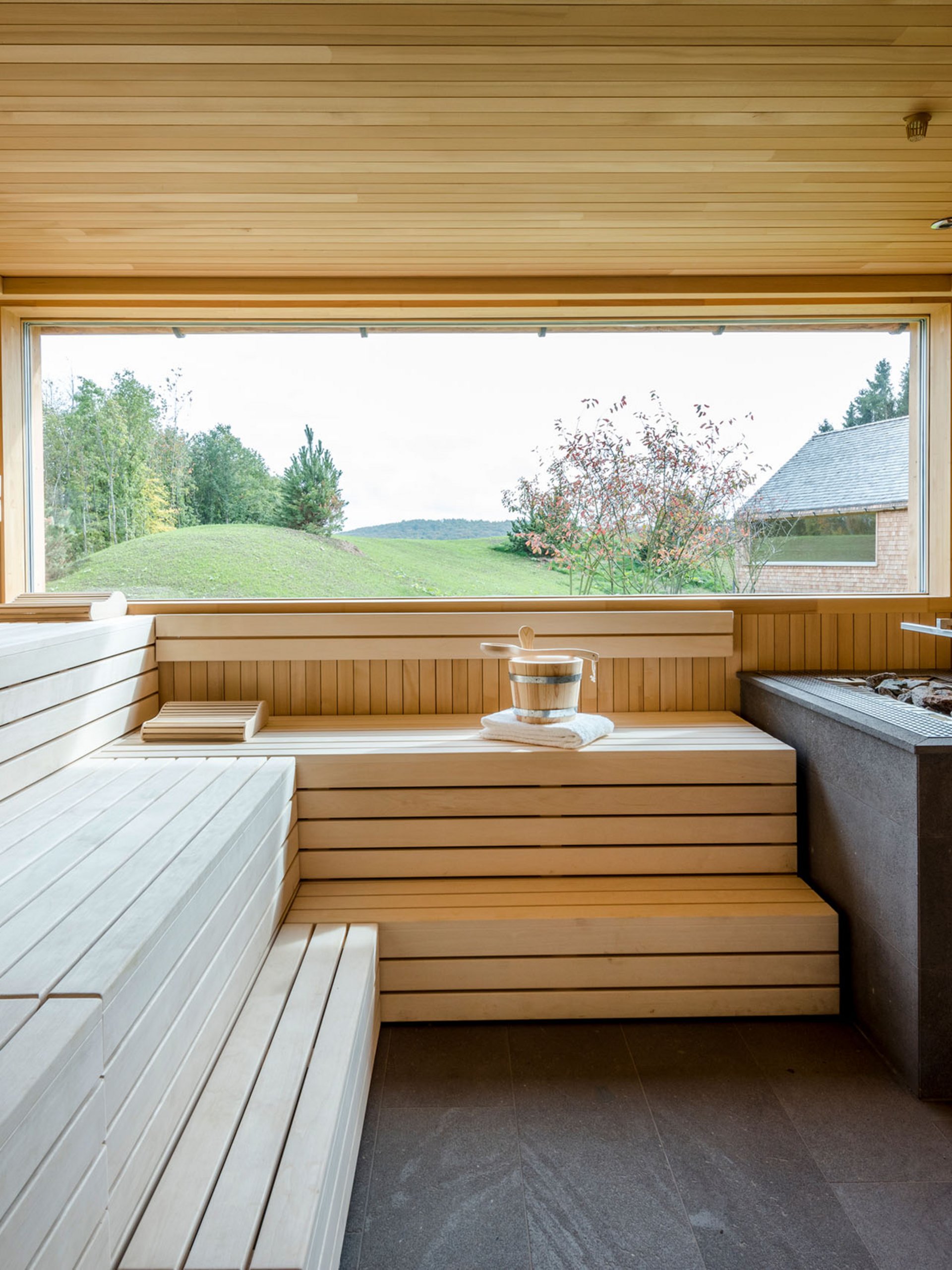 Seezeitlodge: Bildergalerie Moderner Holzsaunaraum mit großem Fenster und Blick auf Landschaft