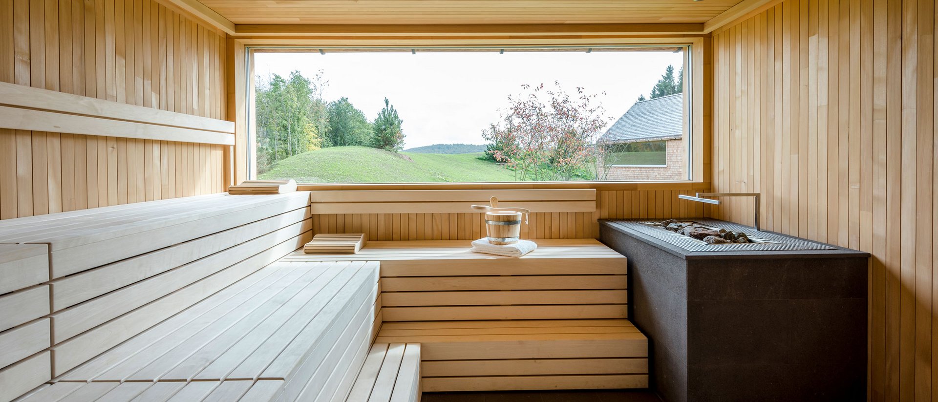 Seezeitlodge: Bildergalerie Moderner Holzsaunaraum mit großem Fenster und Blick auf Landschaft