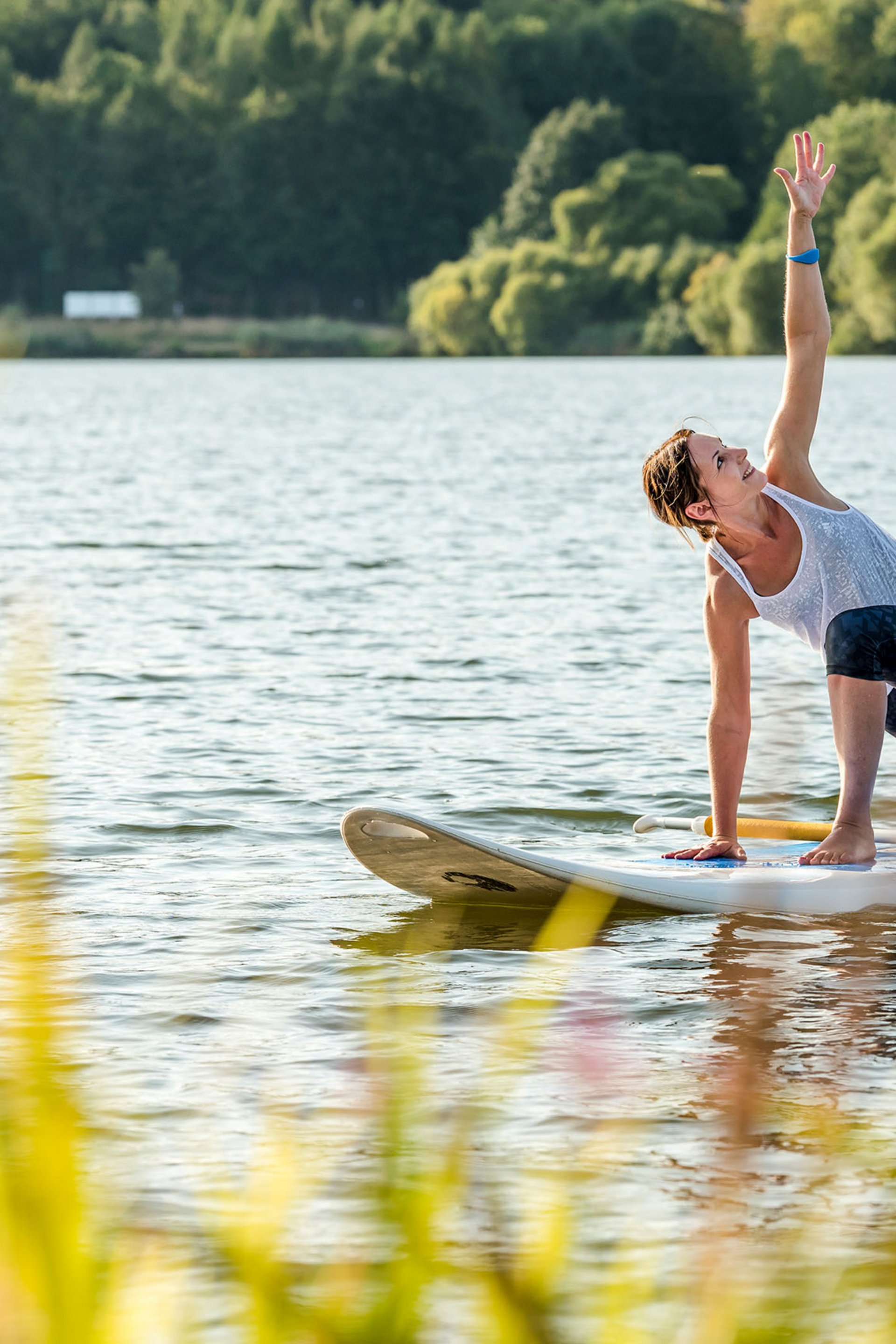 Seezeitlodge : Galerie photos Femme pratiquant le yoga sur une planche de paddle sur un lac