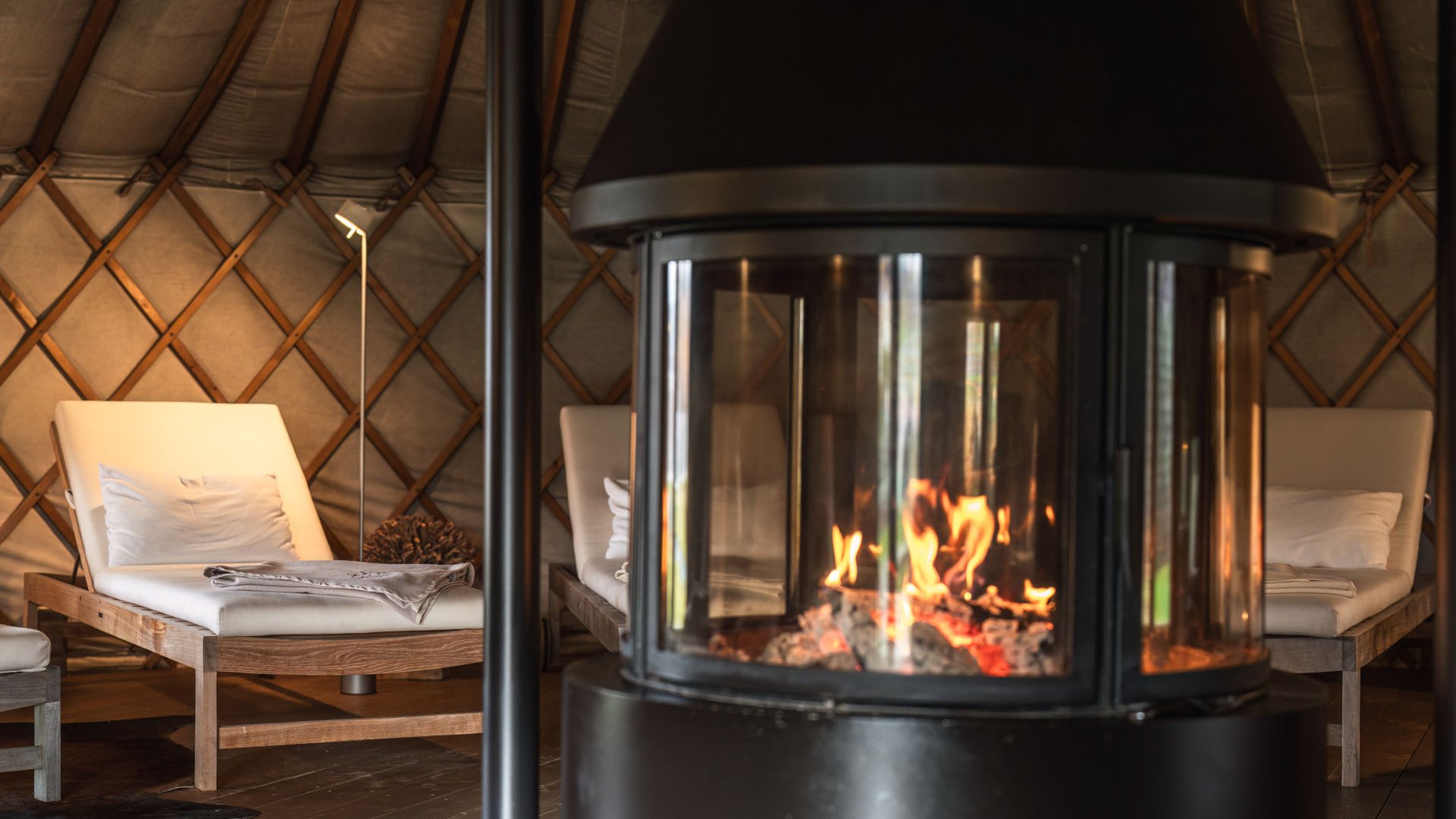 Seezeitlodge: Ihr Spa-Hotel am Bostalsee Flackerndes Feuer im Kamin und gepolsterte Holzliegen in gemütlichem Raum