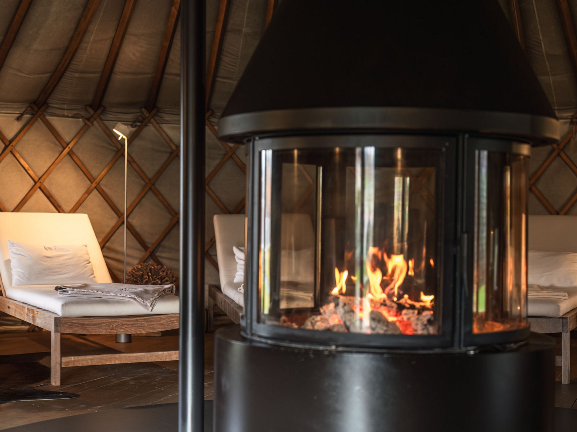 Le Seezeitlodge : votre hôtel au lac de Bostal Feu de cheminée brûlant et chaises longues en bois rembourrées dans une pièce chaleureuse