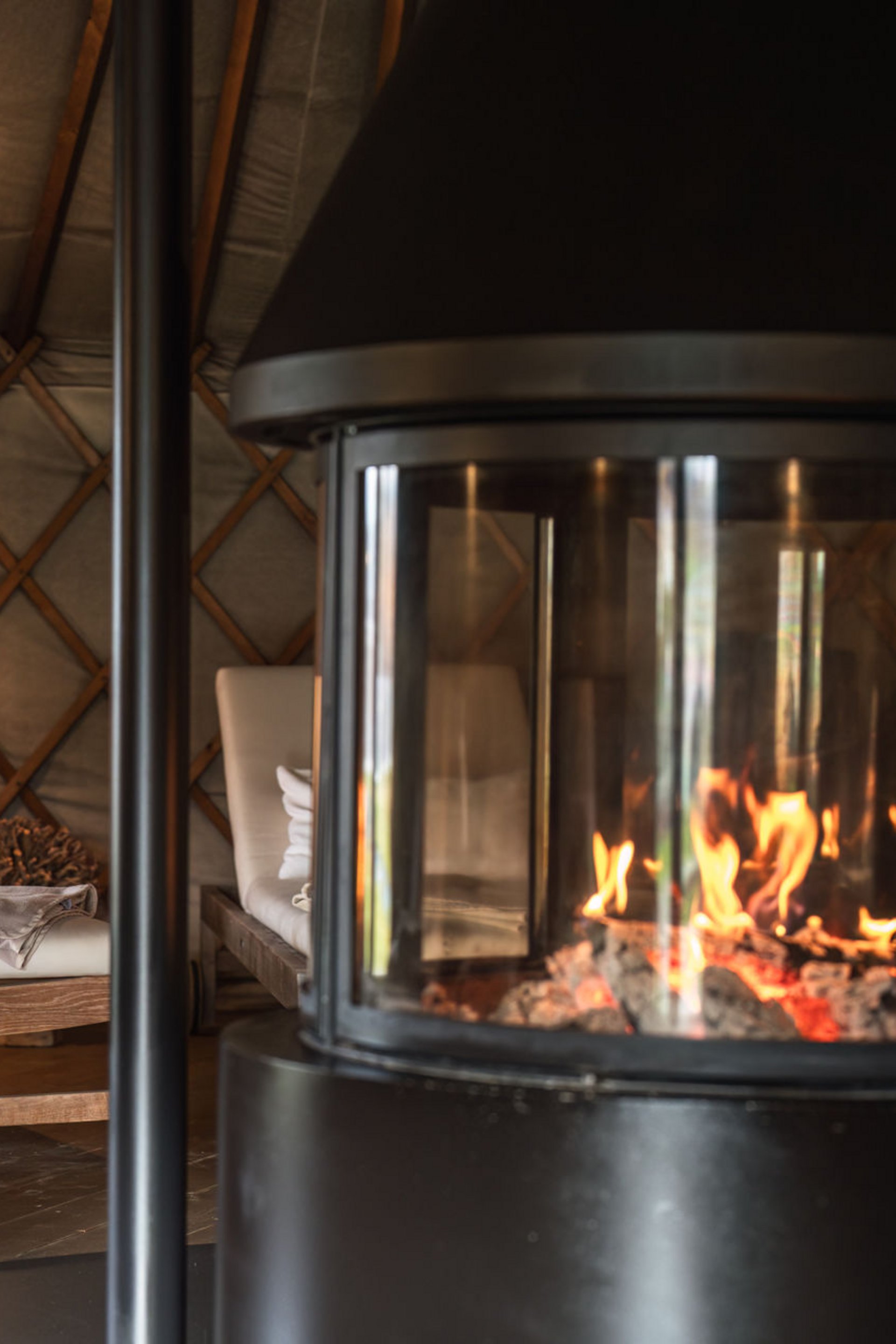 Seezeitlodge: Bildergalerie Flackerndes Feuer im Kamin und gepolsterte Holzliegen in gemütlichem Raum