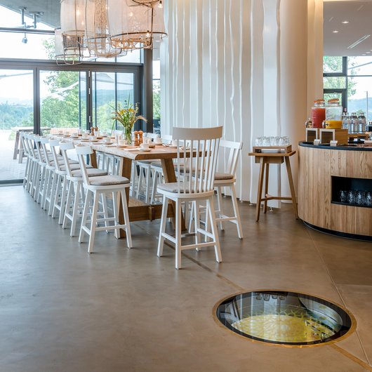 Das Erbe der Kelten erleben: Seezeitlodge Modernes Esszimmer mit langem Holztisch und weißen Stühlen