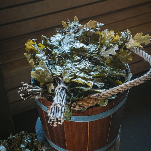 Seezeitlodge: Ihr Spa-Hotel am Bostalsee Holzeimer mit frischen Eichenlaubbündeln in einem Saunaraum