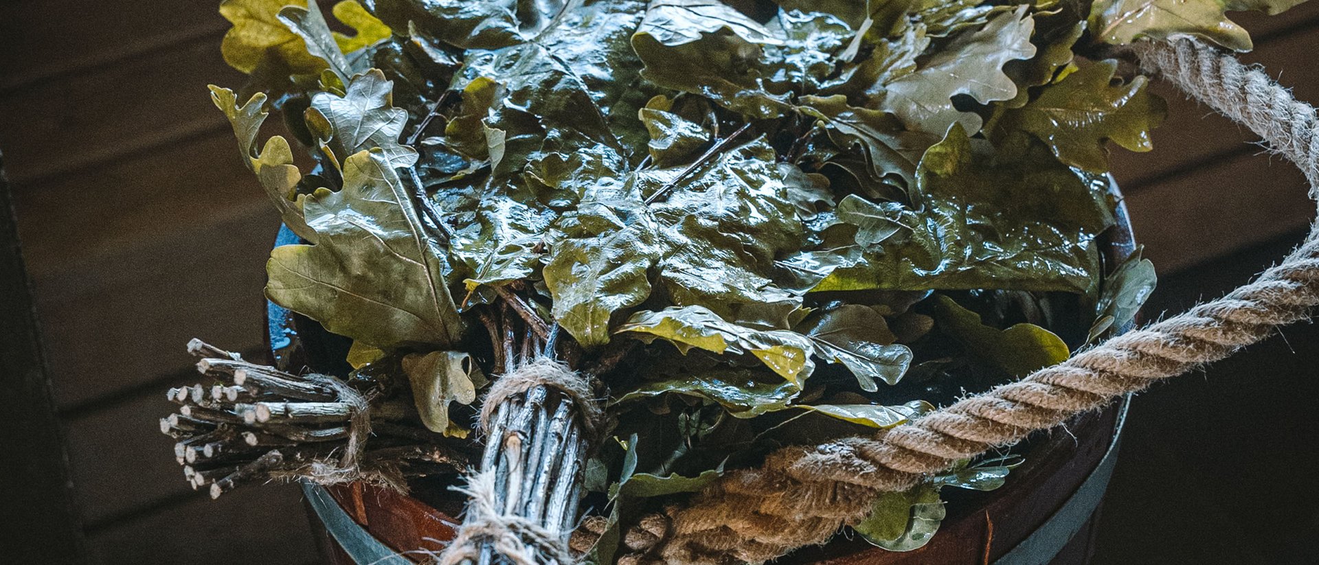 Seezeitlodge: Ihr Wellnesshotel am Bostalsee für pure Erholung Holzeimer mit frischen Eichenlaubbündeln in einem Saunaraum