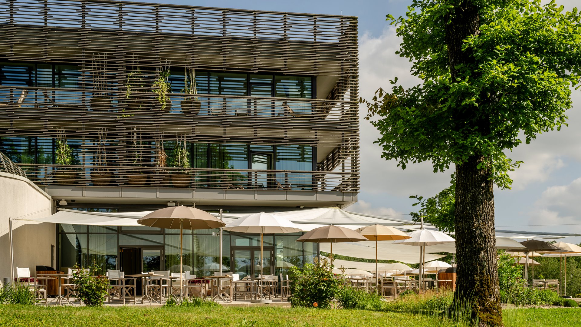 Seezeitlodge : Galerie photos Bâtiment moderne avec terrasse et parasols dans un espace vert
