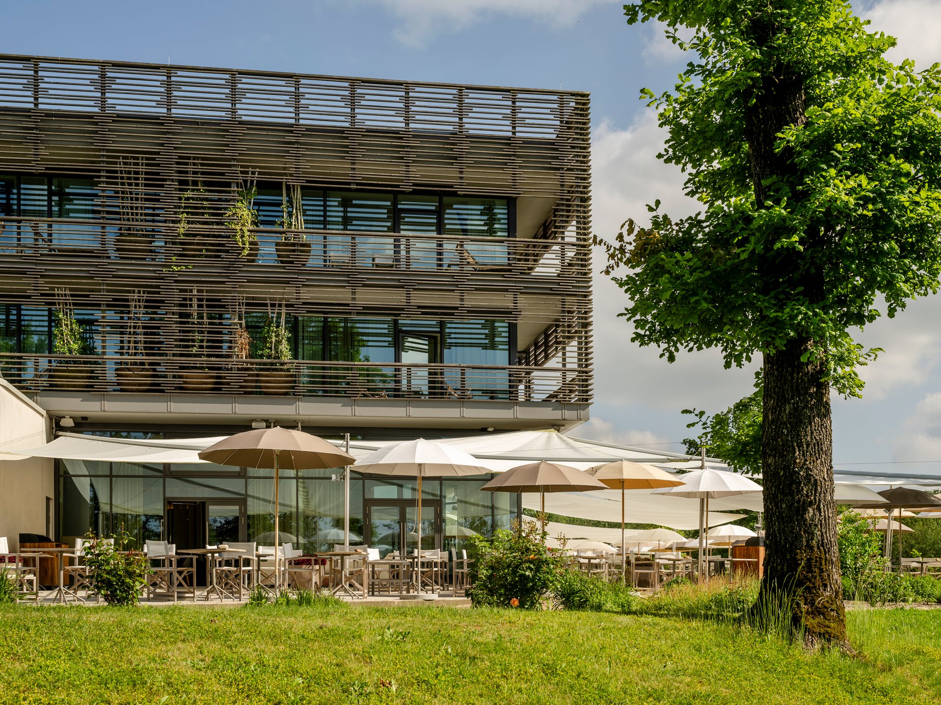 Design hotel Germany: your retreat at Lake Bostalsee Modern building with terrace and umbrellas in a green area