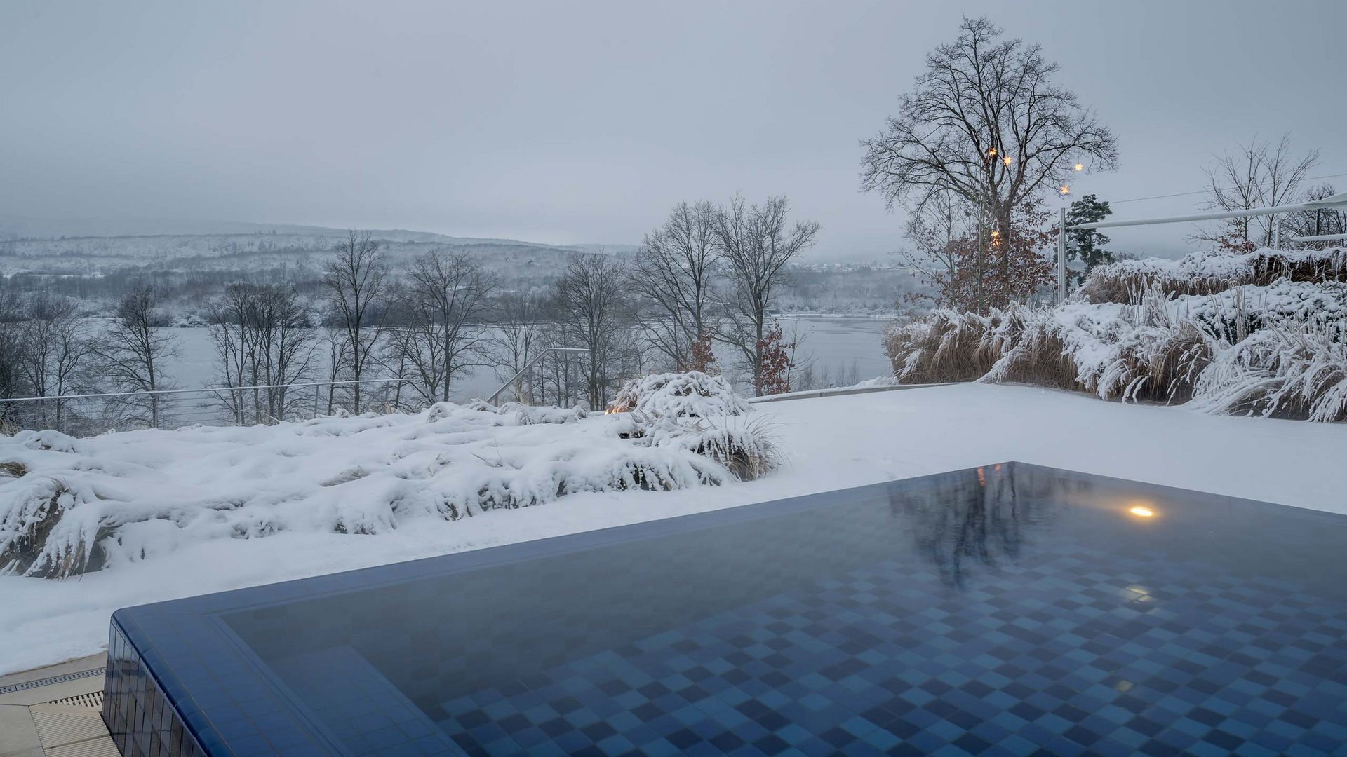 Die Seezeitlodge: Ihr Hotel am Bostalsee Beheizter Außenpool im verschneiten Wintergarten mit Blick auf eine winterliche Landschaft