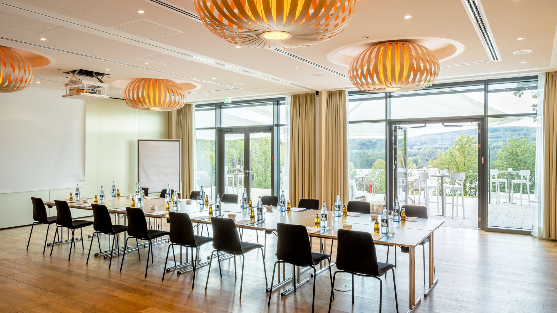 Conference hotel in Saarland: Seezeitlodge at Lake Bostalsee Modern conference room with U-shaped table and view of terrace and nature