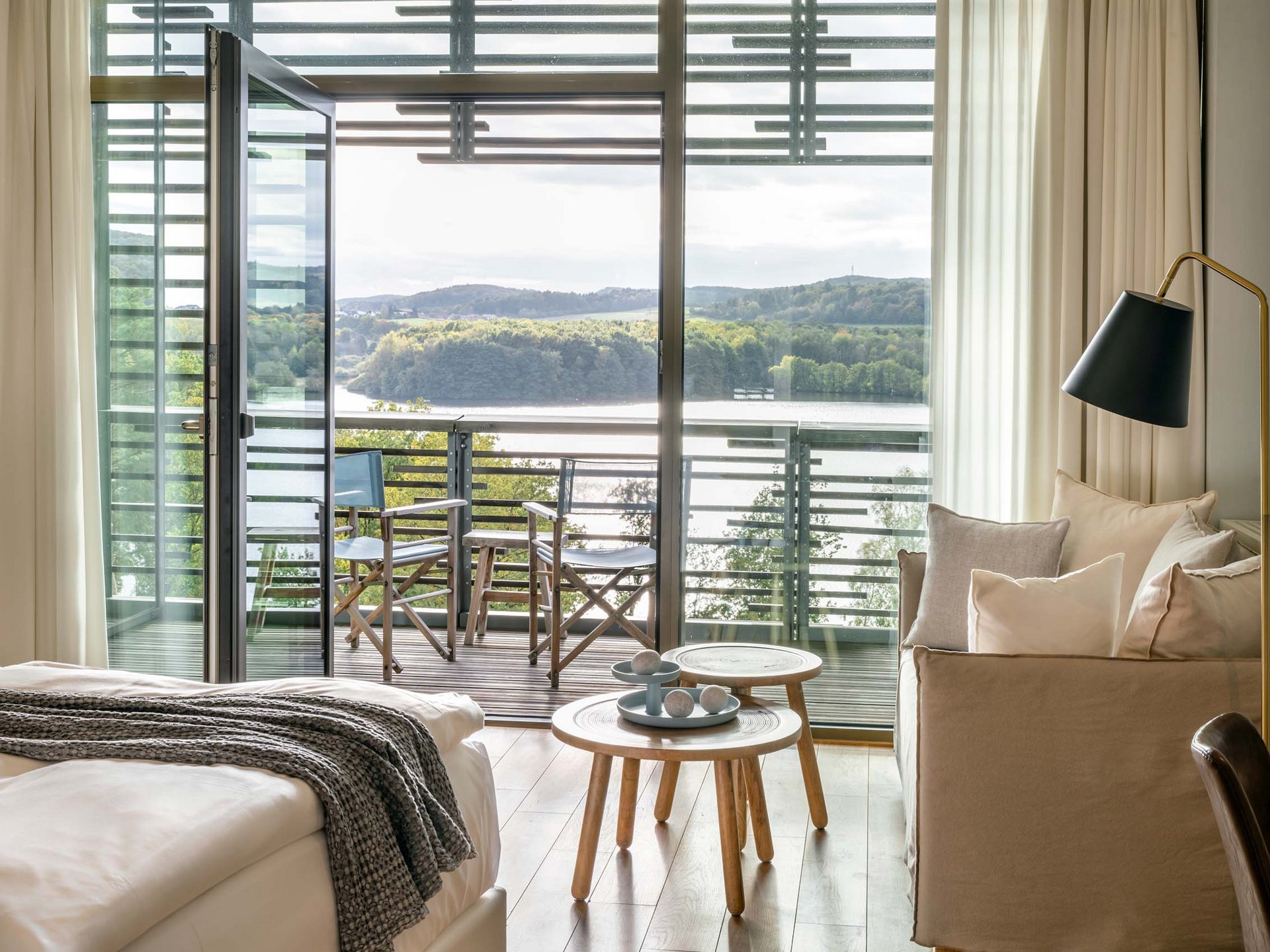 Le Seezeitlodge : votre hôtel au lac de Bostal Chambre d'hôtel confortable avec balcon et vue sur lac et forêt