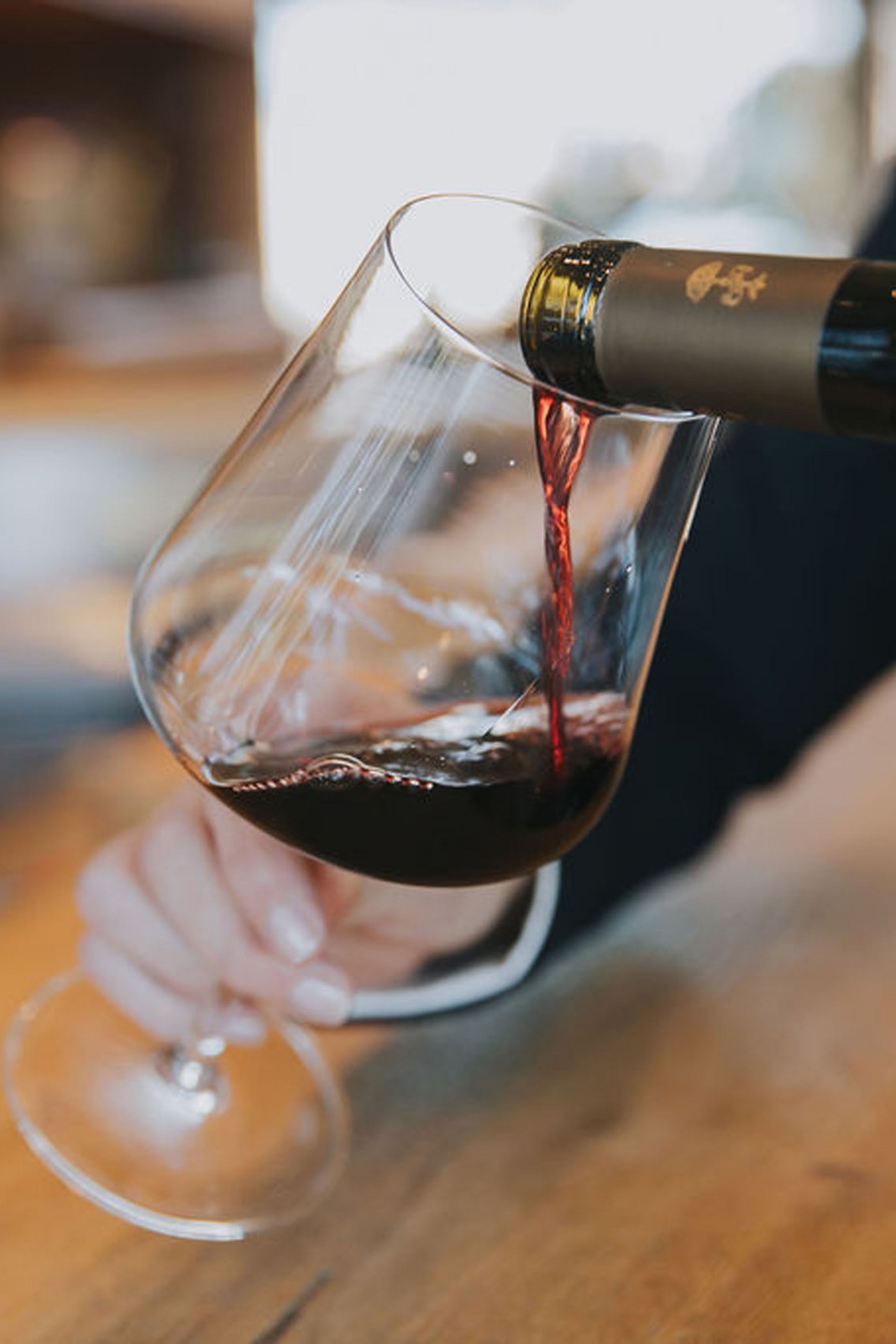 Seezeitlodge: Bildergalerie Rotwein wird in ein Glas an einer Bar eingeschenkt