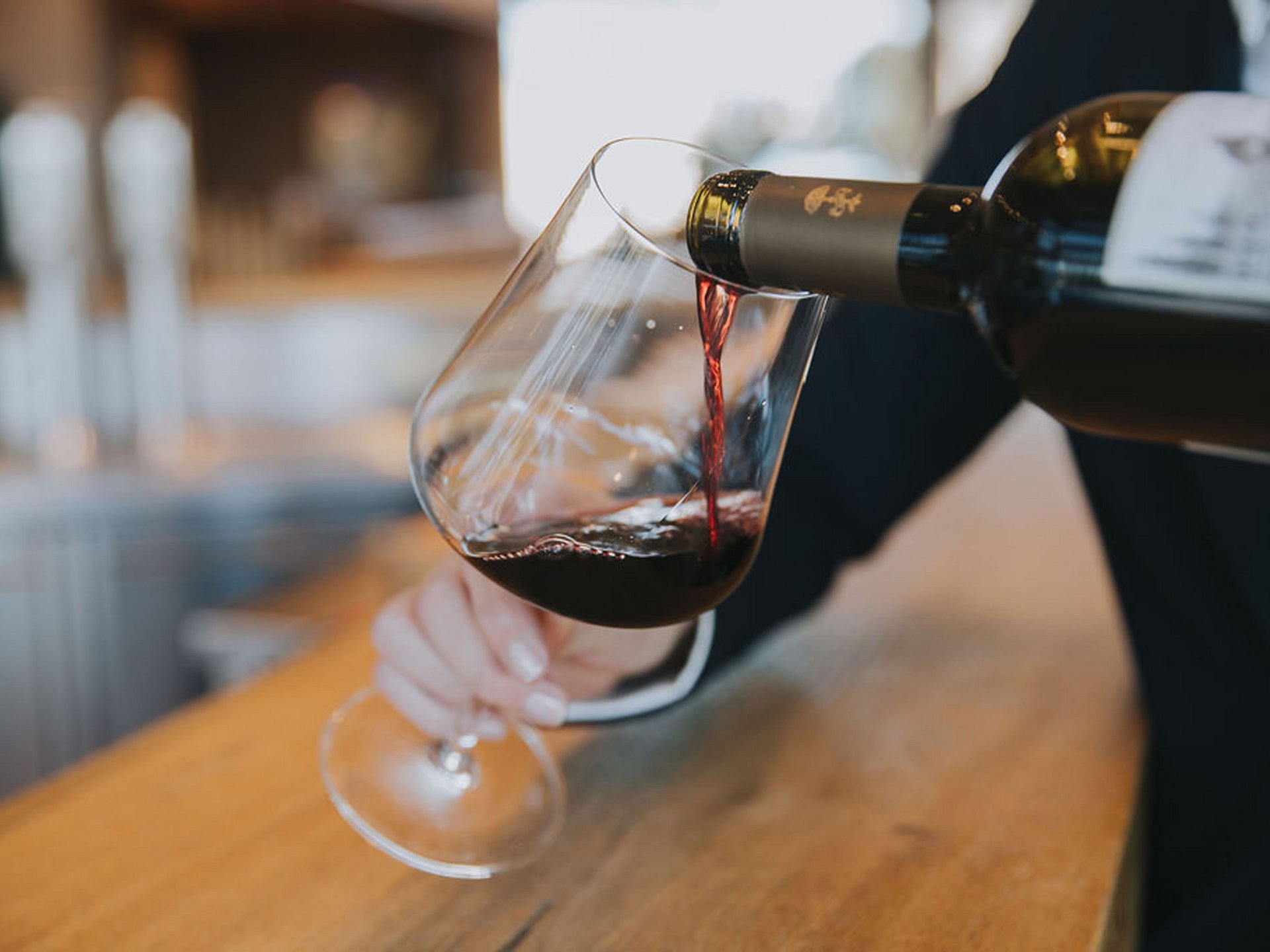 Seezeitlodge: Bildergalerie Rotwein wird in ein Glas an einer Bar eingeschenkt