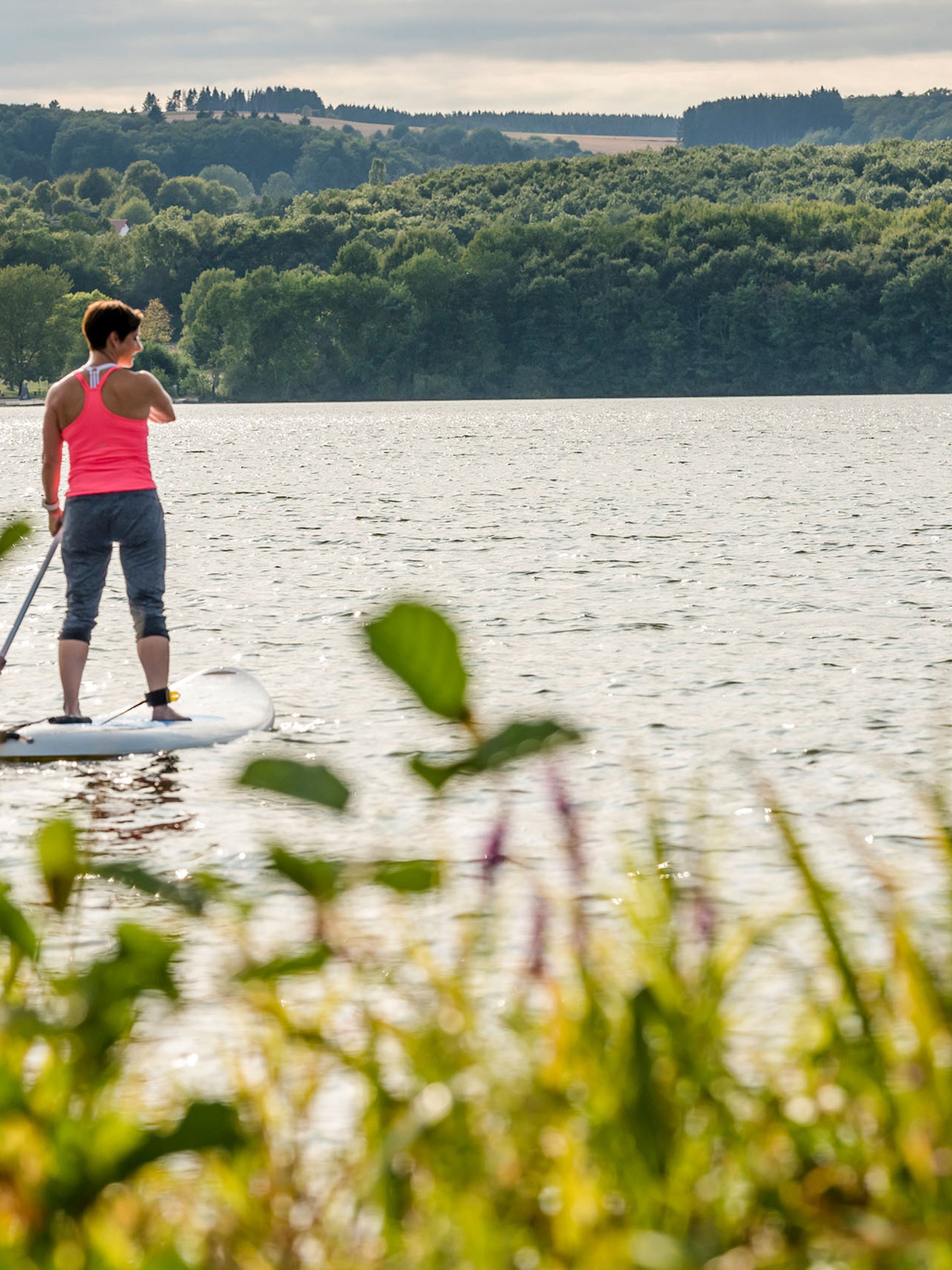 Seezeitlodge : Galerie photos Deux femmes en paddle sur un lac entouré de forêt
