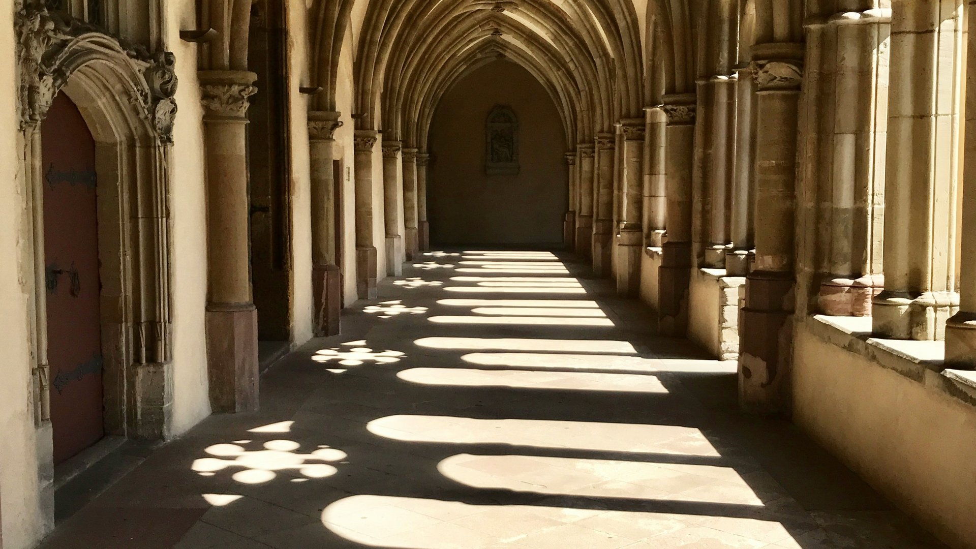 Seezeitlodge: Lieblingsgeschichten Licht und Schatten in einem gotischen Klostergang mit Spitzbögen