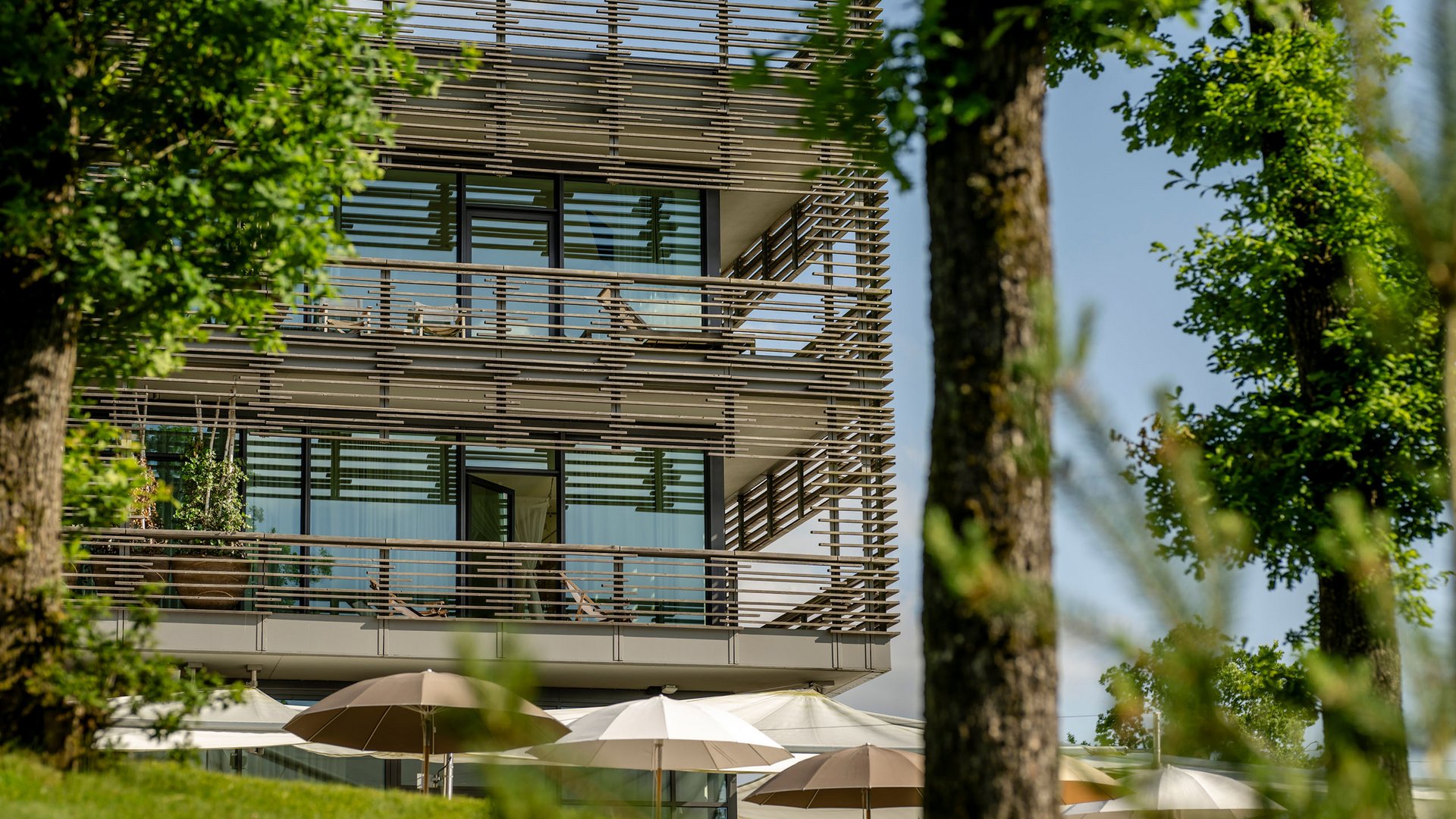 Seezeitlodge : protection des données Bâtiment moderne avec grandes fenêtres vitrées et parasols dans le jardin