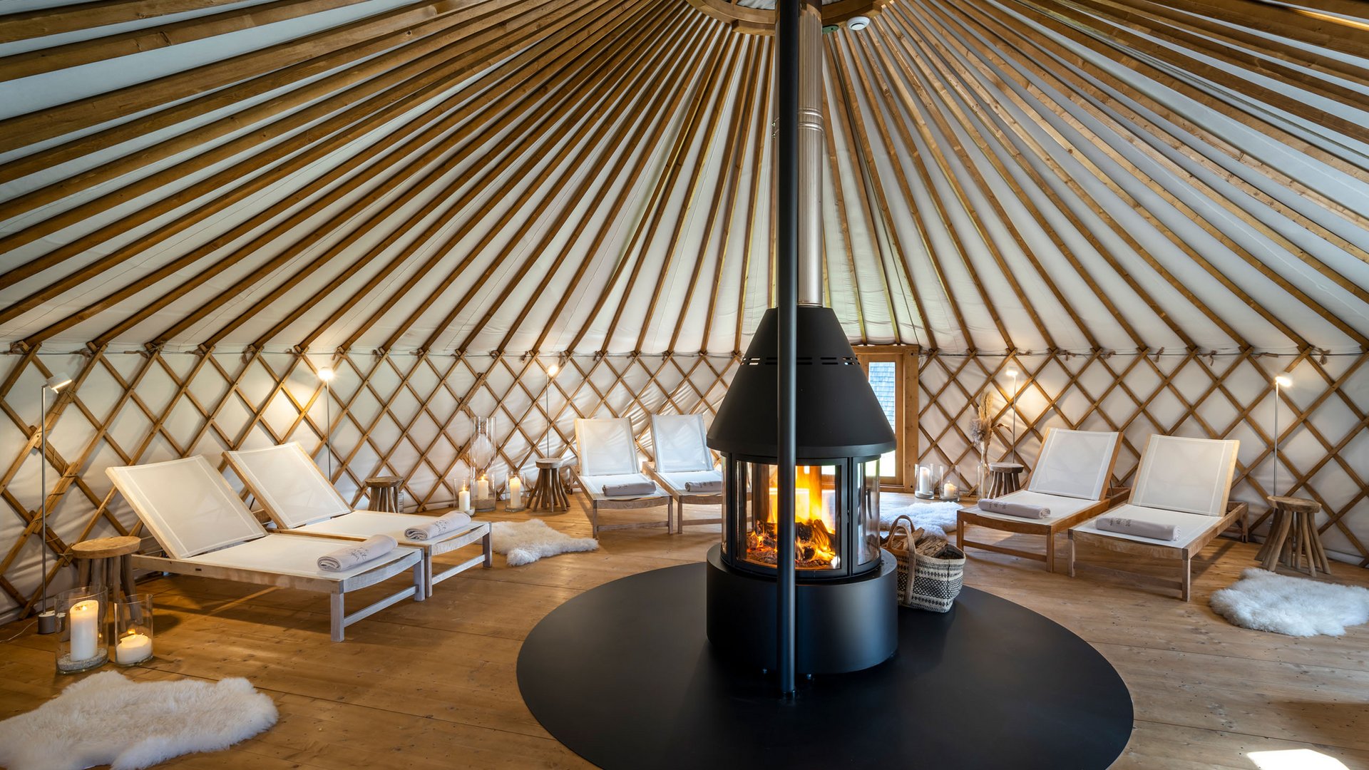 Seezeitlodge : Galerie photos Intérieur d'une yourte avec cheminée et chaises longues