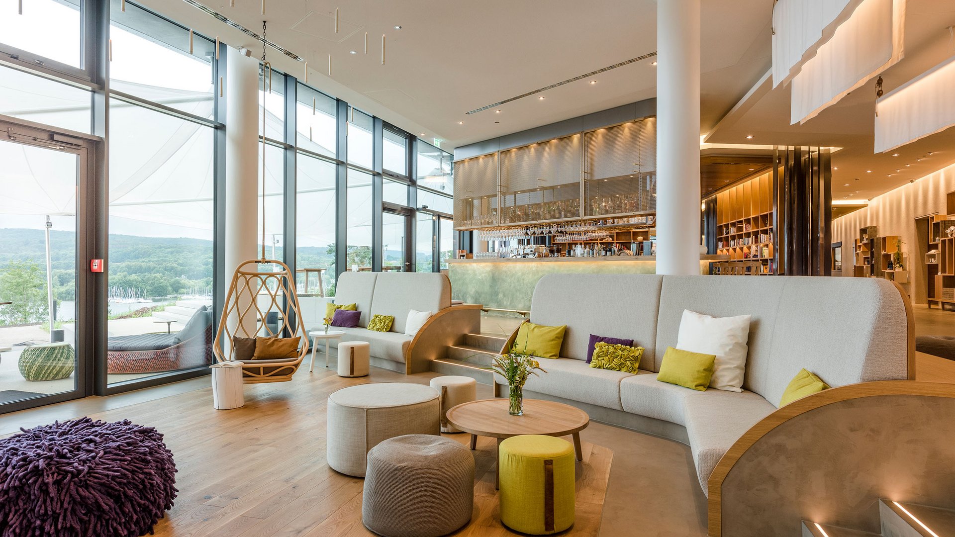 Seezeitlodge : Galerie photos Salon moderne avec grandes fenêtres, sièges et un coin bar