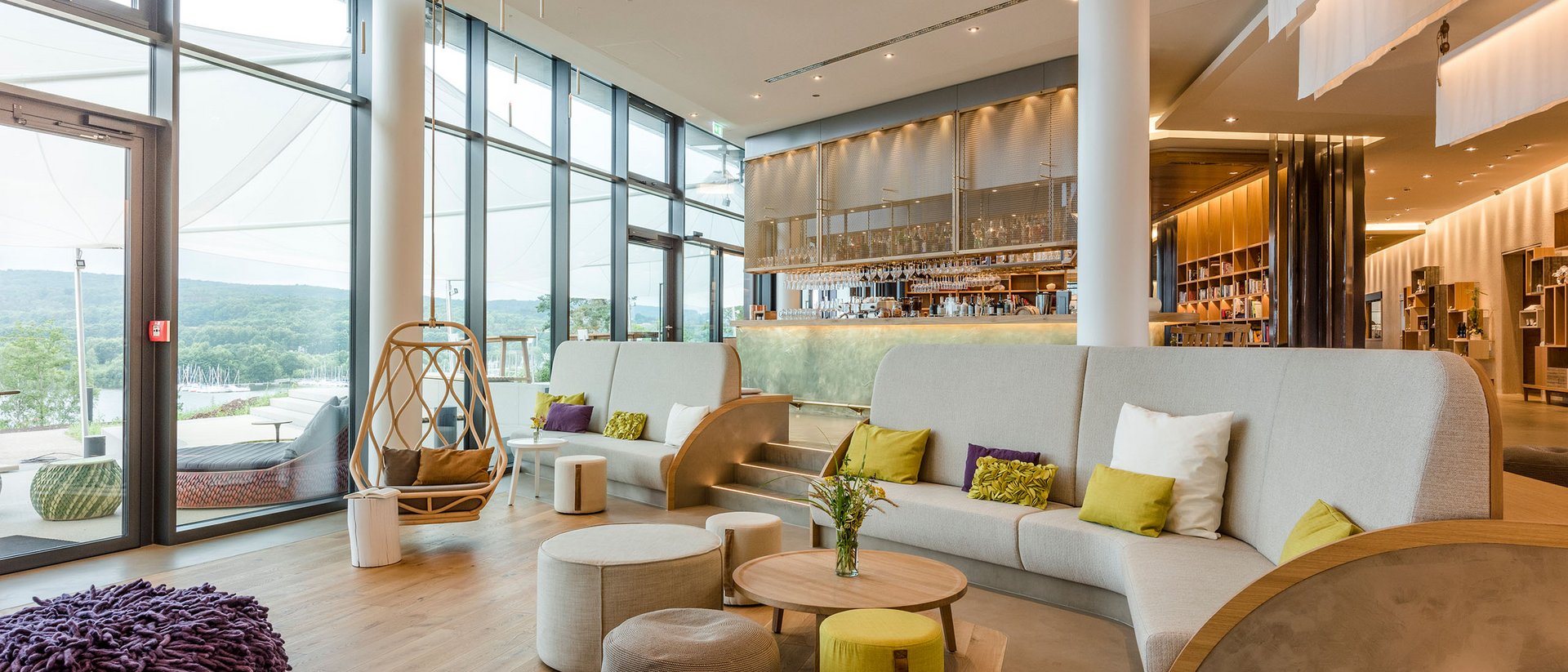 Seezeitlodge : Galerie photos Salon moderne avec grandes fenêtres, sièges et un coin bar