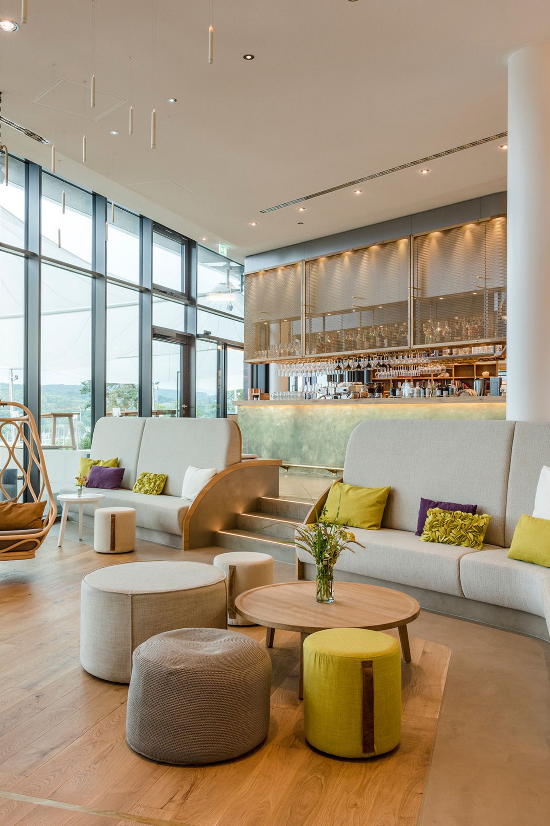 Seezeitlodge: Bildergalerie Moderne Lounge mit großen Fenstern, Sitzgelegenheiten und Barbereich