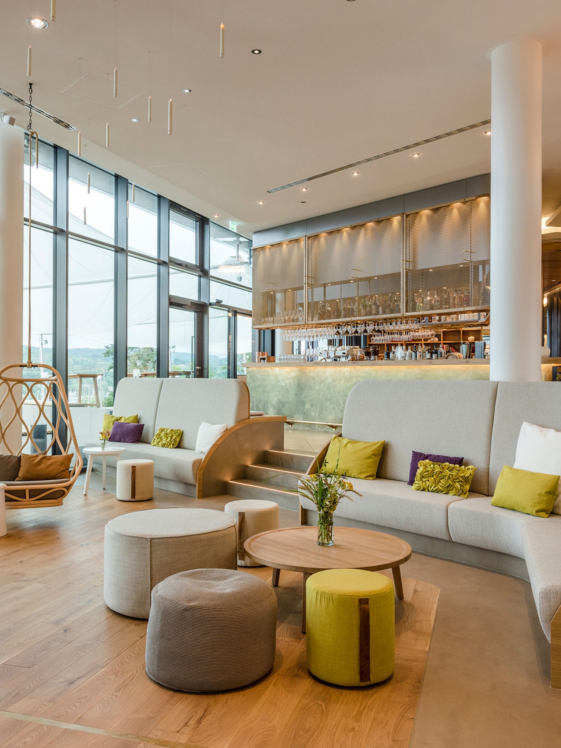 Seezeitlodge: Bildergalerie Moderne Lounge mit großen Fenstern, Sitzgelegenheiten und Barbereich