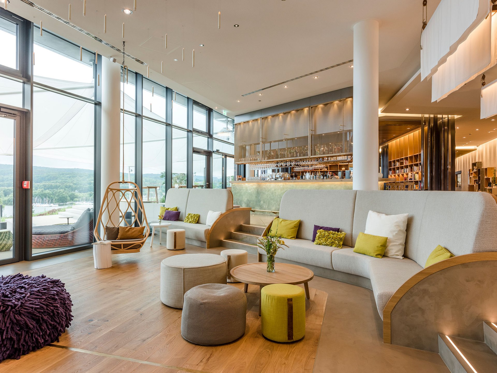 Seezeitlodge : Galerie photos Salon moderne avec grandes fenêtres, sièges et un coin bar