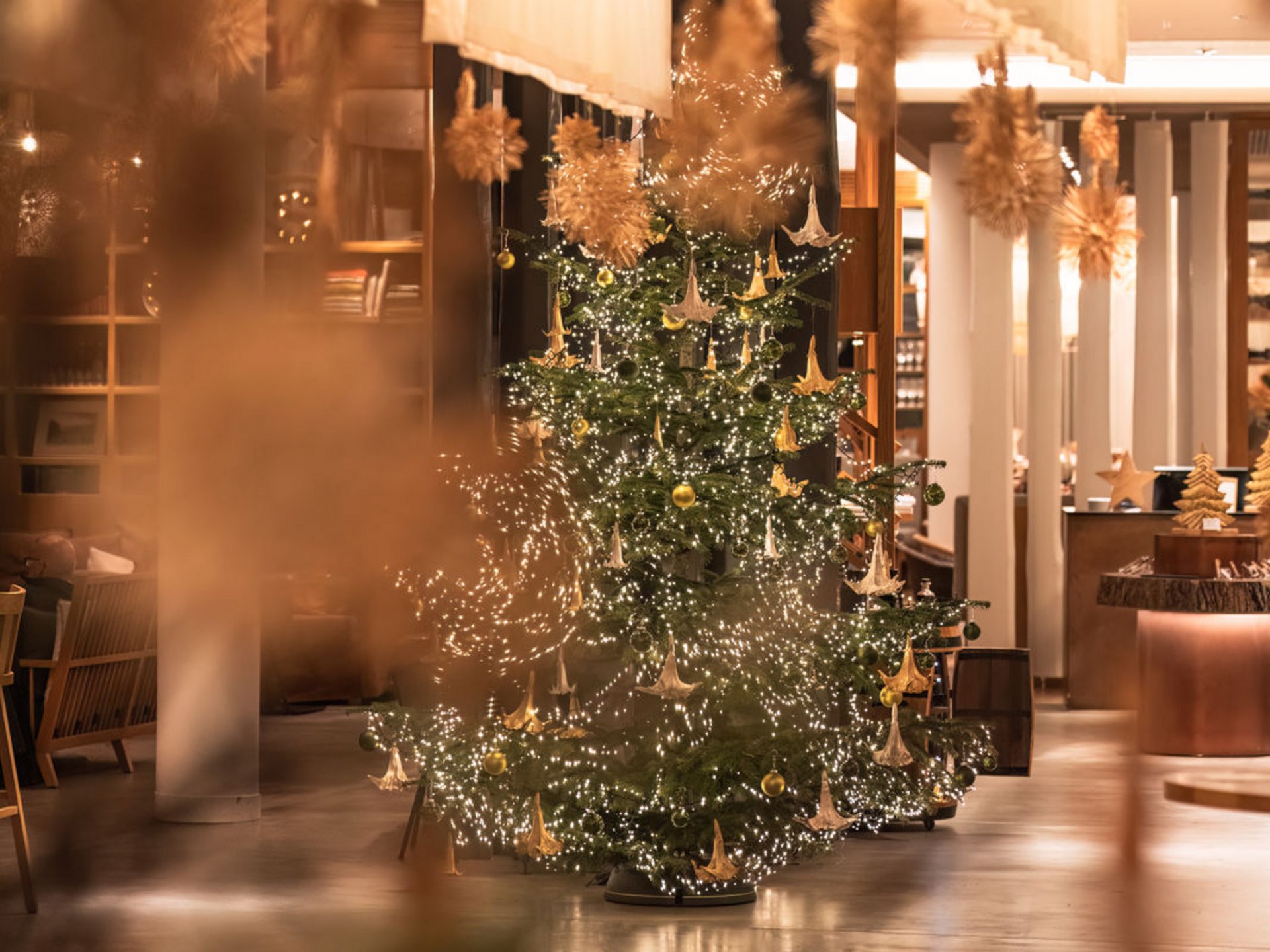 Weihnachtsstimmung am Bostalsee Weihnachtsbaum mit goldenen Ornamenten und Lichtern in einem modern dekorierten Raum