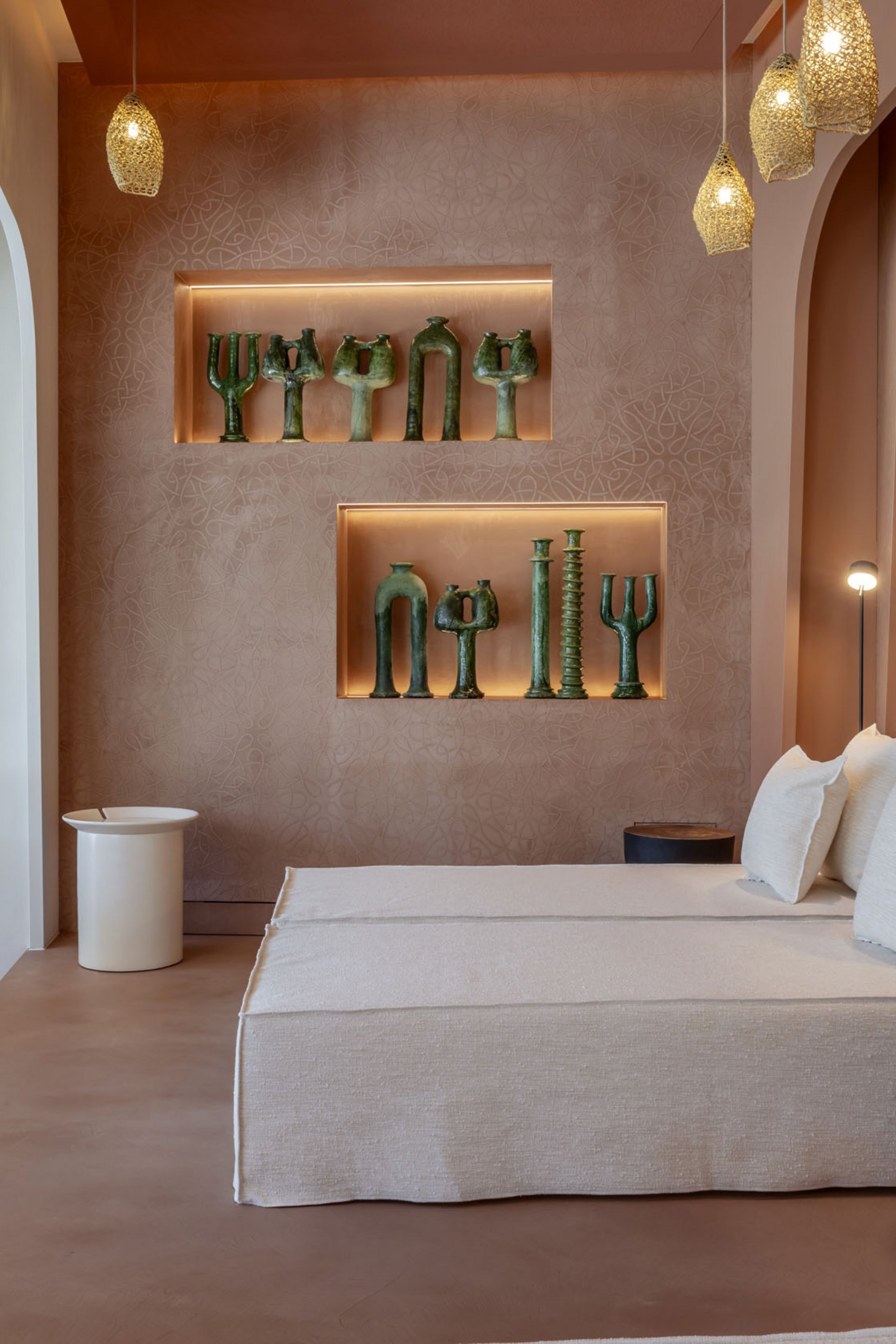 Seezeitlodge: Bildergalerie Modernes Wohnzimmer mit beiger Couch, Akzentbeleuchtung und grünen Skulpturen an der Wand.