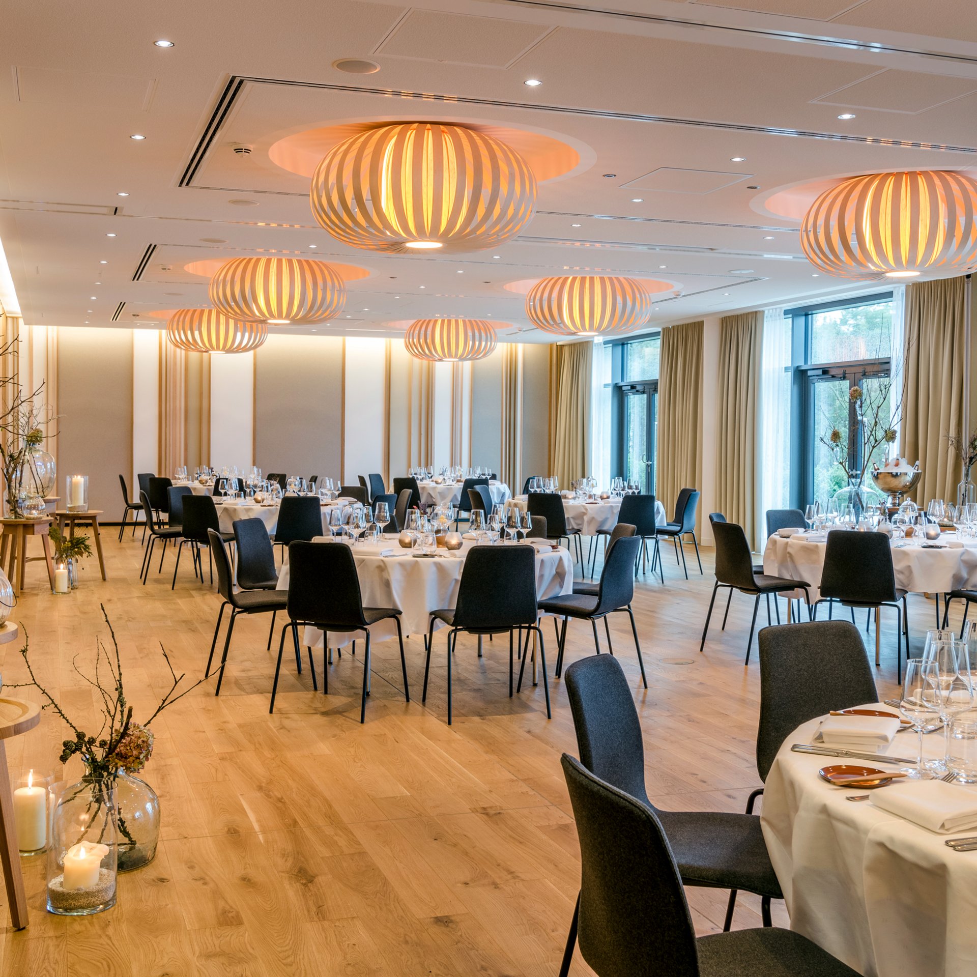 Le Seezeitlodge : votre hôtel au lac de Bostal Salle à manger élégante avec tables rondes dressées et éclairage moderne
