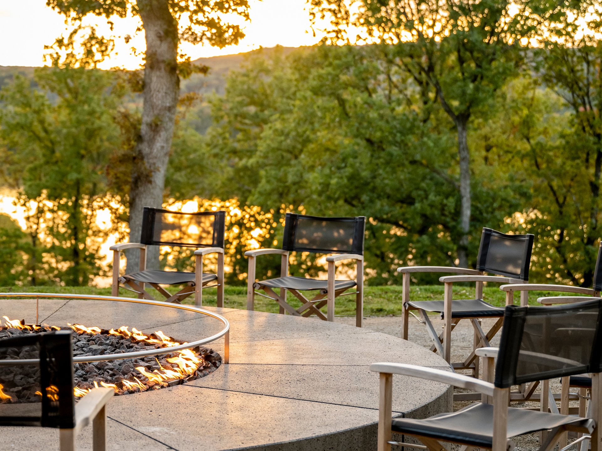 Keltische Mythen - LieblingsGeschichten Blog Runde Feuerschale mit Stühlen draußen vor Bäumen bei Sonnenuntergang