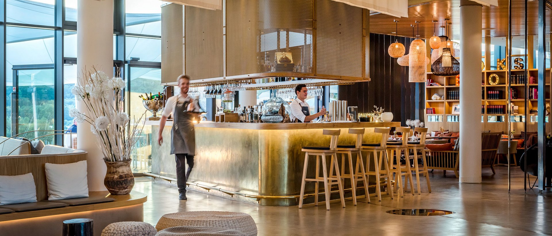 Seezeitlodge: Bildergalerie Moderner Hotelbarbereich mit Bartresen aus Messing und Mitarbeitern