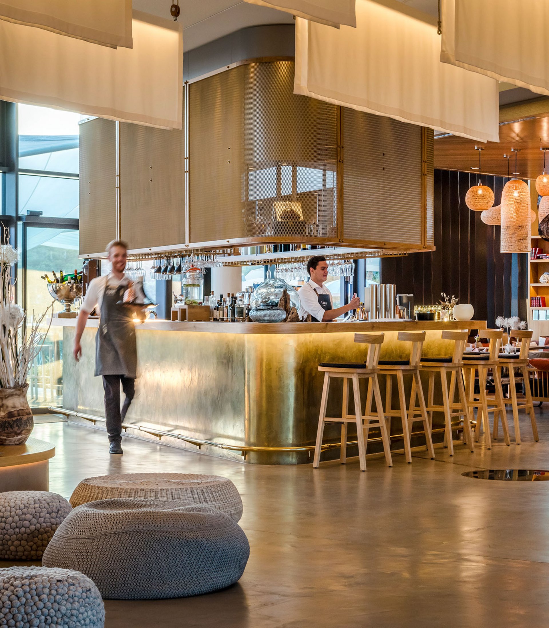 Seezeitlodge: your hotel at Lake Bostalsee Modern hotel bar with brass counter and staff members