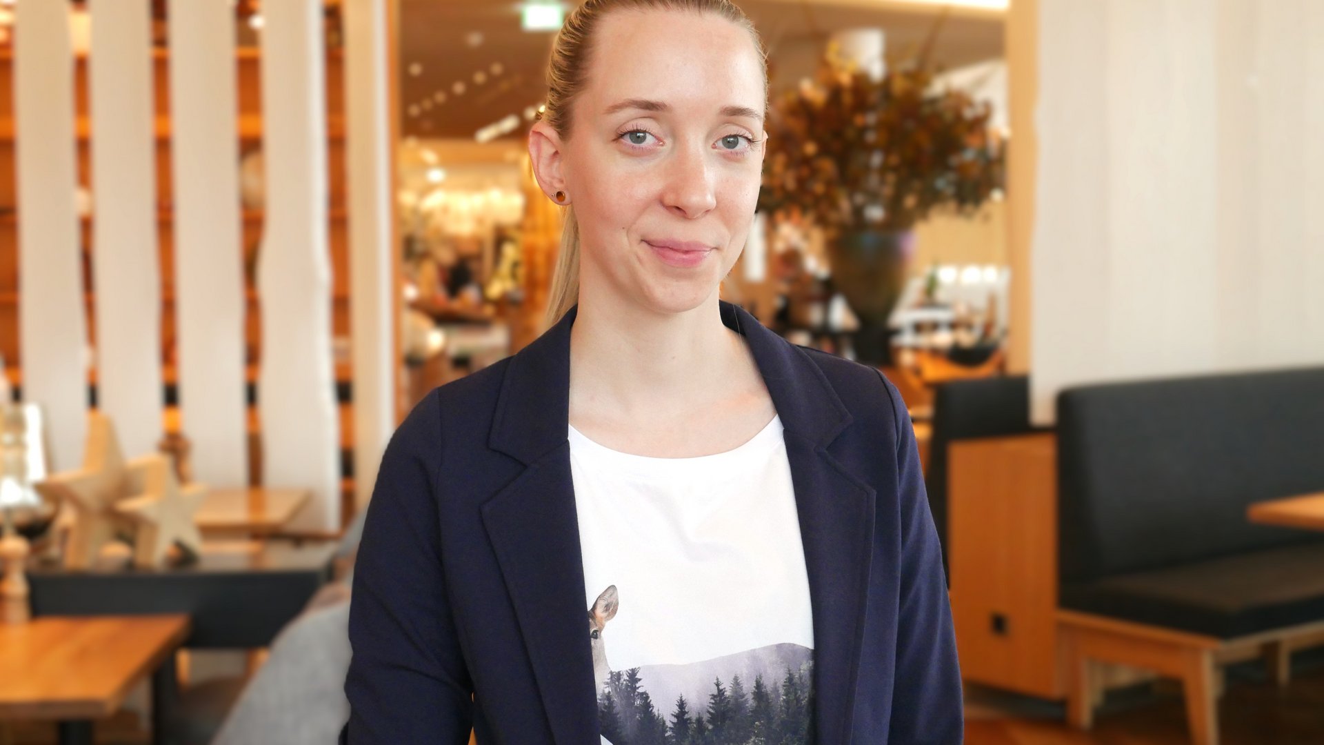 Seezeitlodge: Gastgeber mit Herz Frau lächelt in die Kamera, im Hintergrund ist ein Restaurant