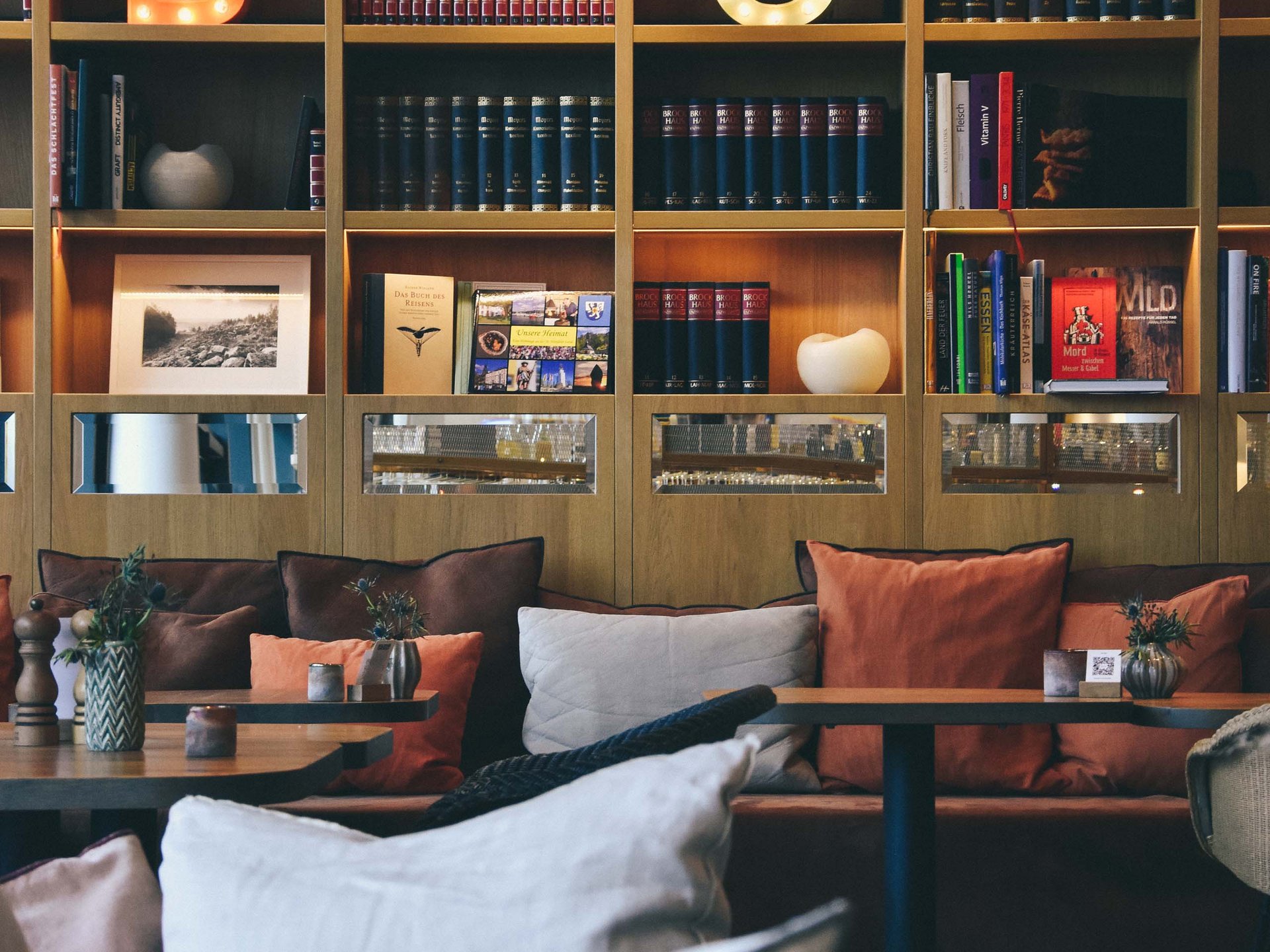 Le Seezeitlodge : votre hôtel au lac de Bostal Café confortable avec canapé, coussins et lettres lumineuses sur l'étagère