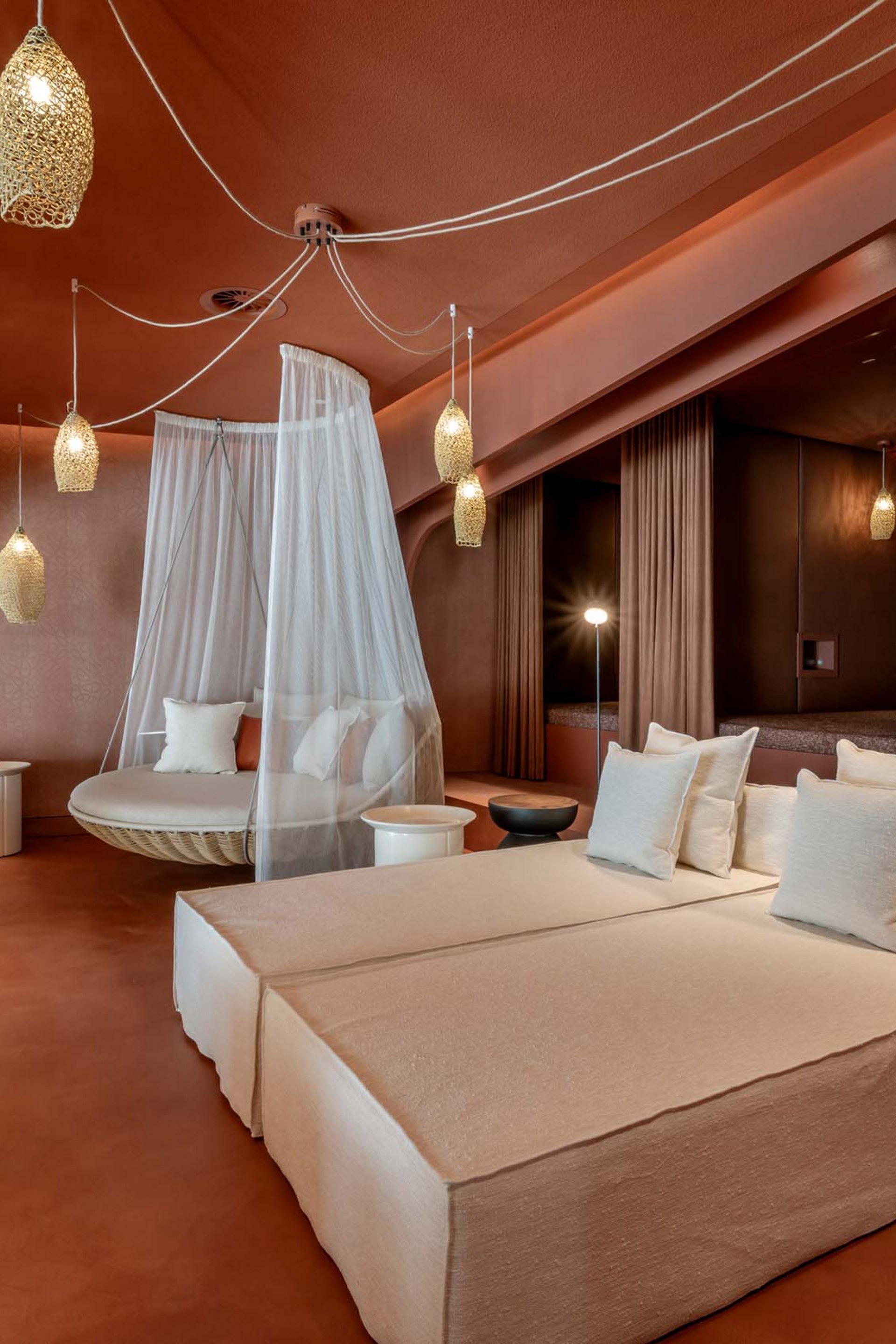 Seezeitlodge: Bildergalerie Moderne Lounge mit beigen Sofas, Hängesessel mit Netz und warmen Beleuchtungen