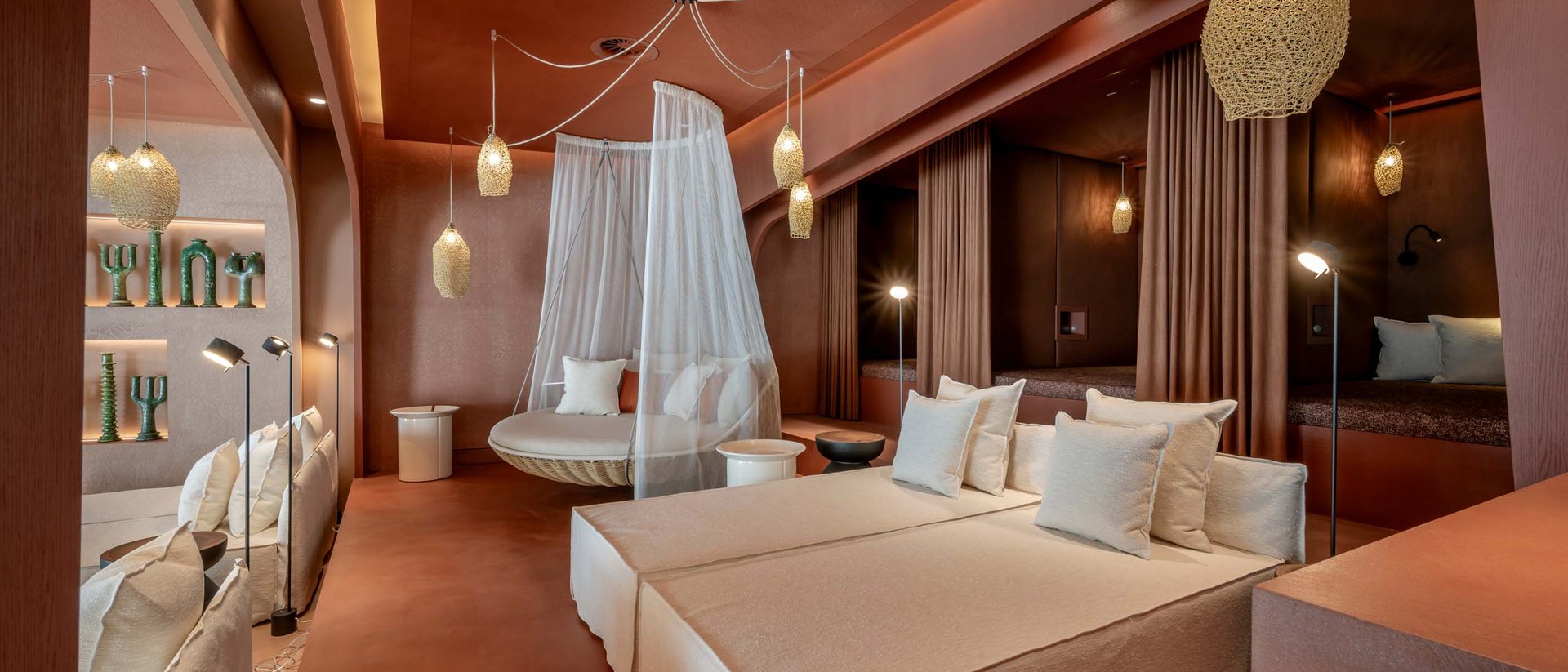 Seezeitlodge : Galerie photos Salon moderne avec canapés beige, fauteuil suspendu en filet et éclairage chaleureux