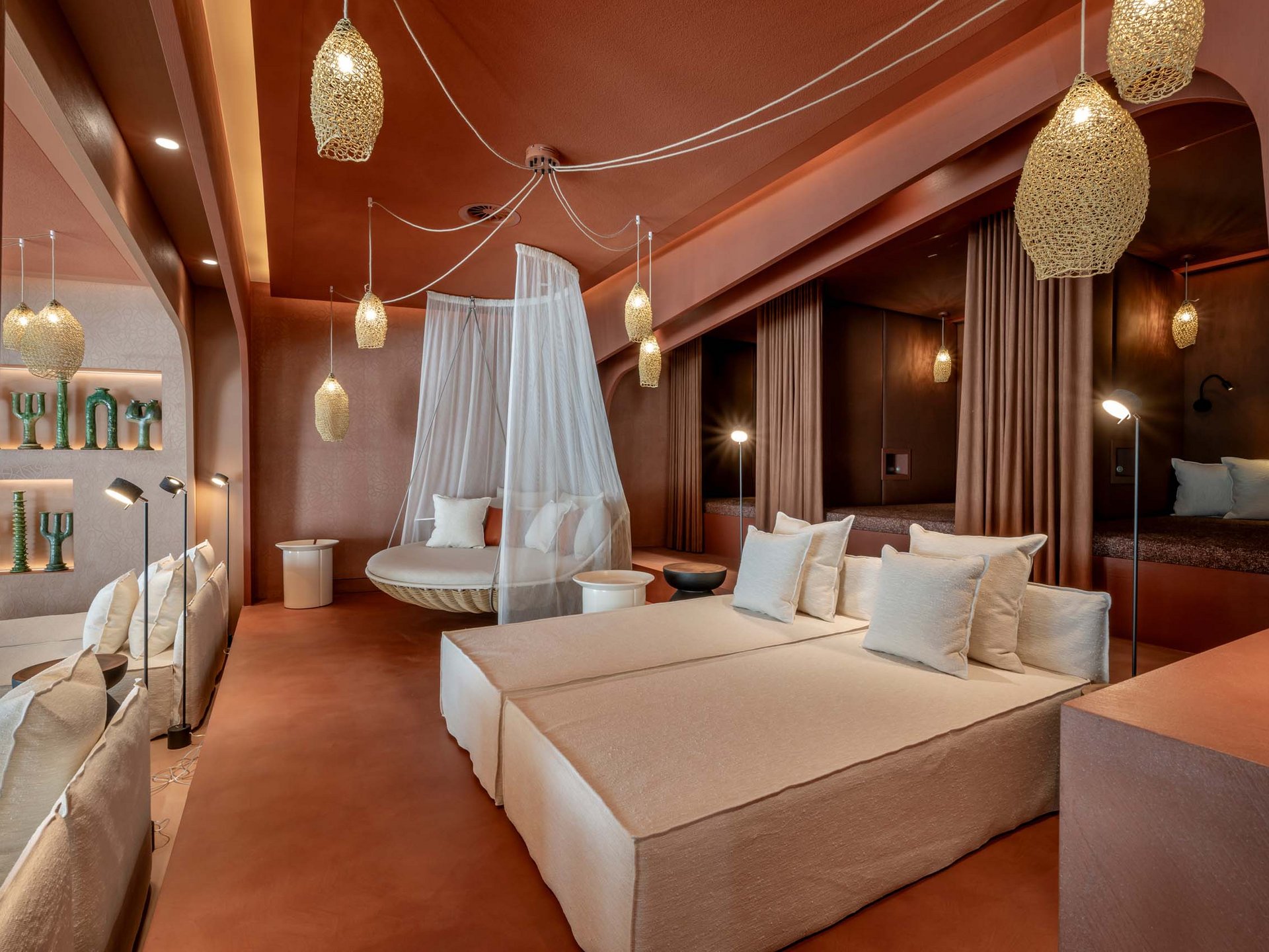 Seezeitlodge : Galerie photos Salon moderne avec canapés beige, fauteuil suspendu en filet et éclairage chaleureux