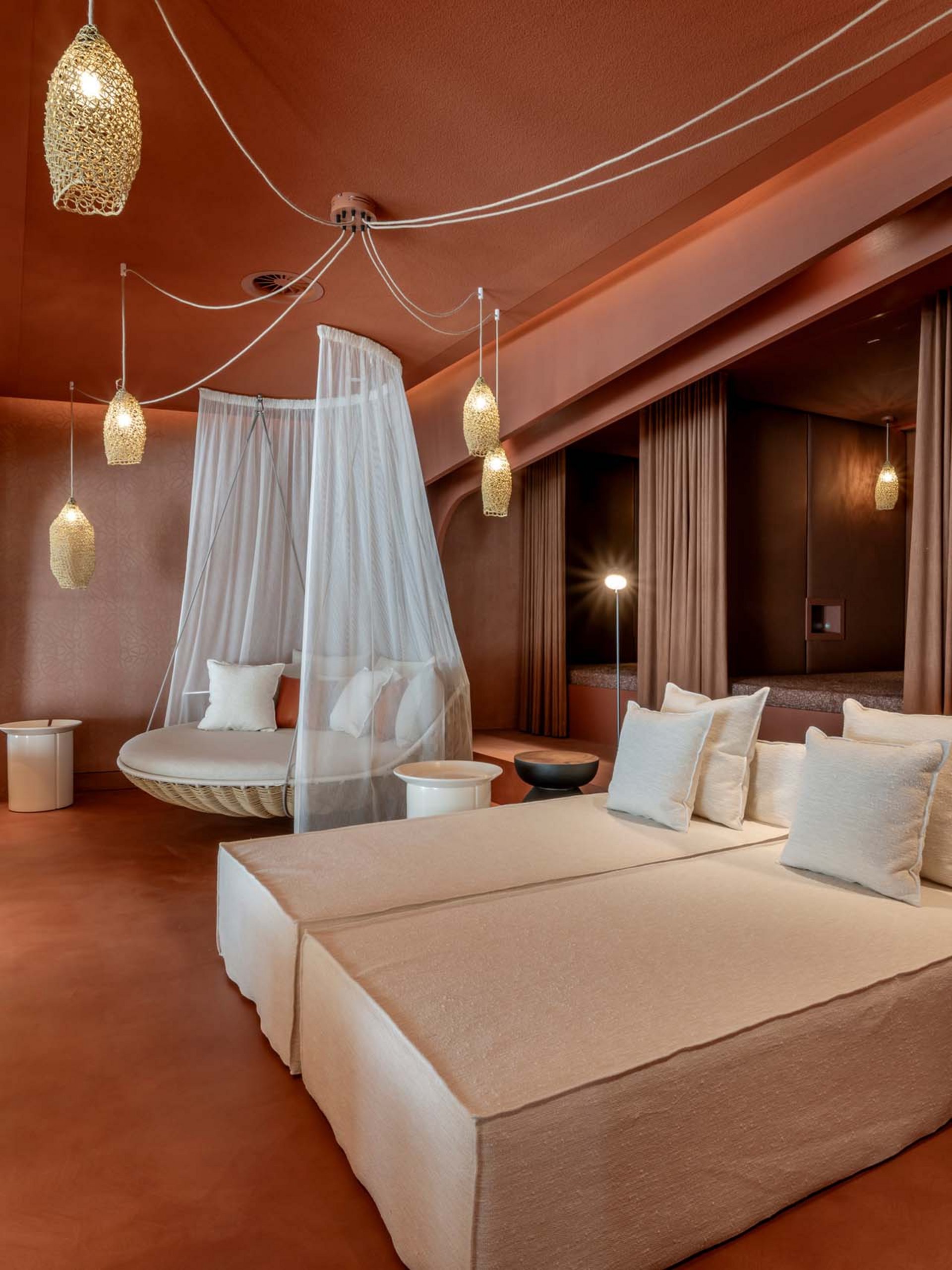 Seezeitlodge: Bildergalerie Moderne Lounge mit beigen Sofas, Hängesessel mit Netz und warmen Beleuchtungen