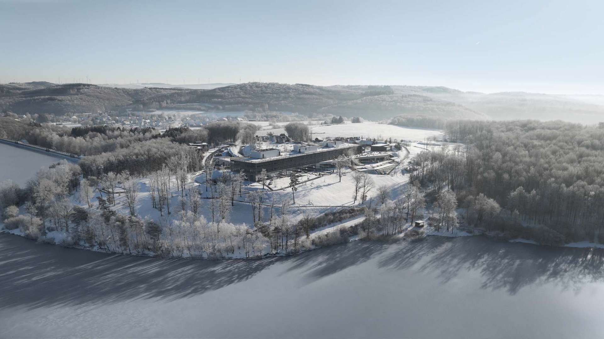 Die Seezeitlodge: Ihr Hotel am Bostalsee Luftaufnahme eines Gebäudekomplexes am verschneiten Ufer eines Sees