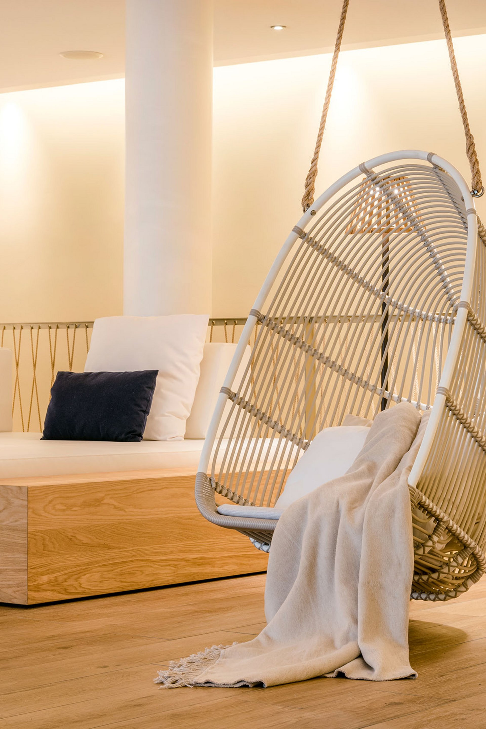 Seezeitlodge : Galerie photos Espace lounge confortable avec fauteuil suspendu, coussins et lampe sur pied