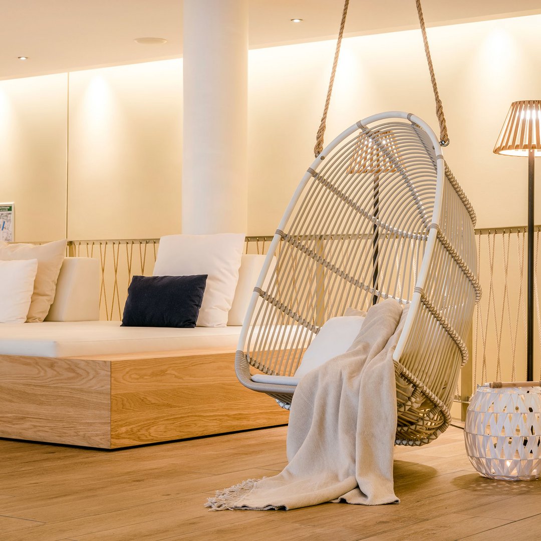 Seezeitlodge : protection des données Espace lounge confortable avec fauteuil suspendu, coussins et lampe sur pied