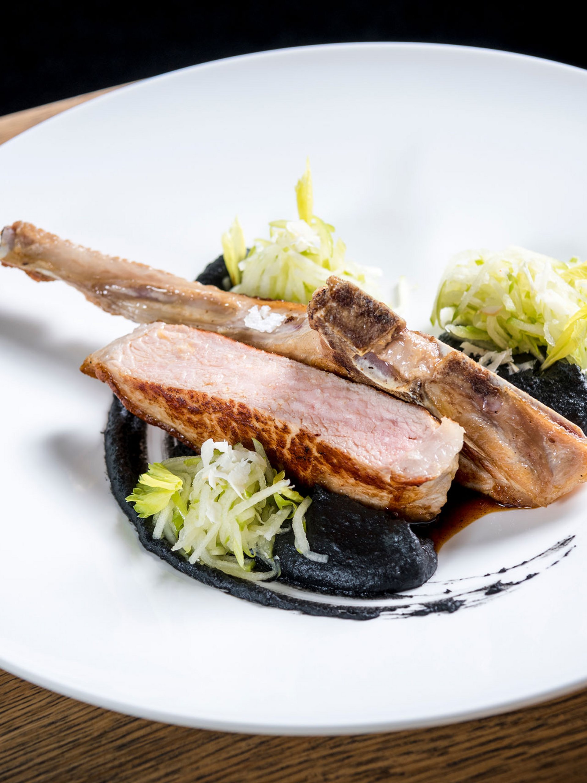 Seezeitlodge : Galerie photos Côtelette d'agneau rôtie avec sauce noire, salade et verre de vin rouge